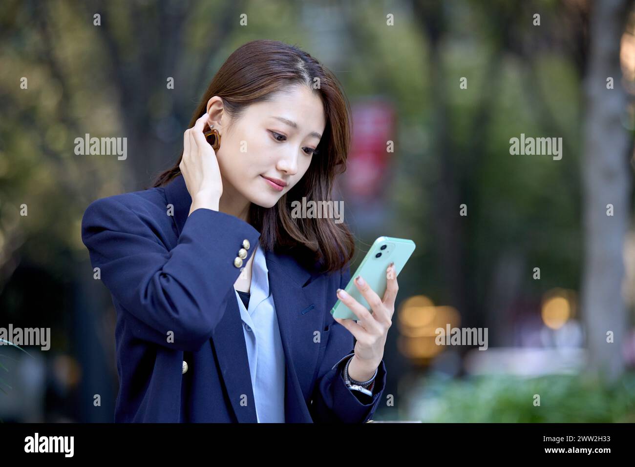Une femme en costume d'affaires utilisant son téléphone portable Banque D'Images
