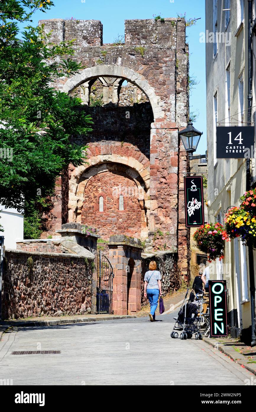 Vue sur le château de Rougemont (également connu sous le nom de château d'Exter) gatehouse ruines dans le centre-ville avec un café à droite, Exeter, Devon, Royaume-Uni, Europe. Banque D'Images