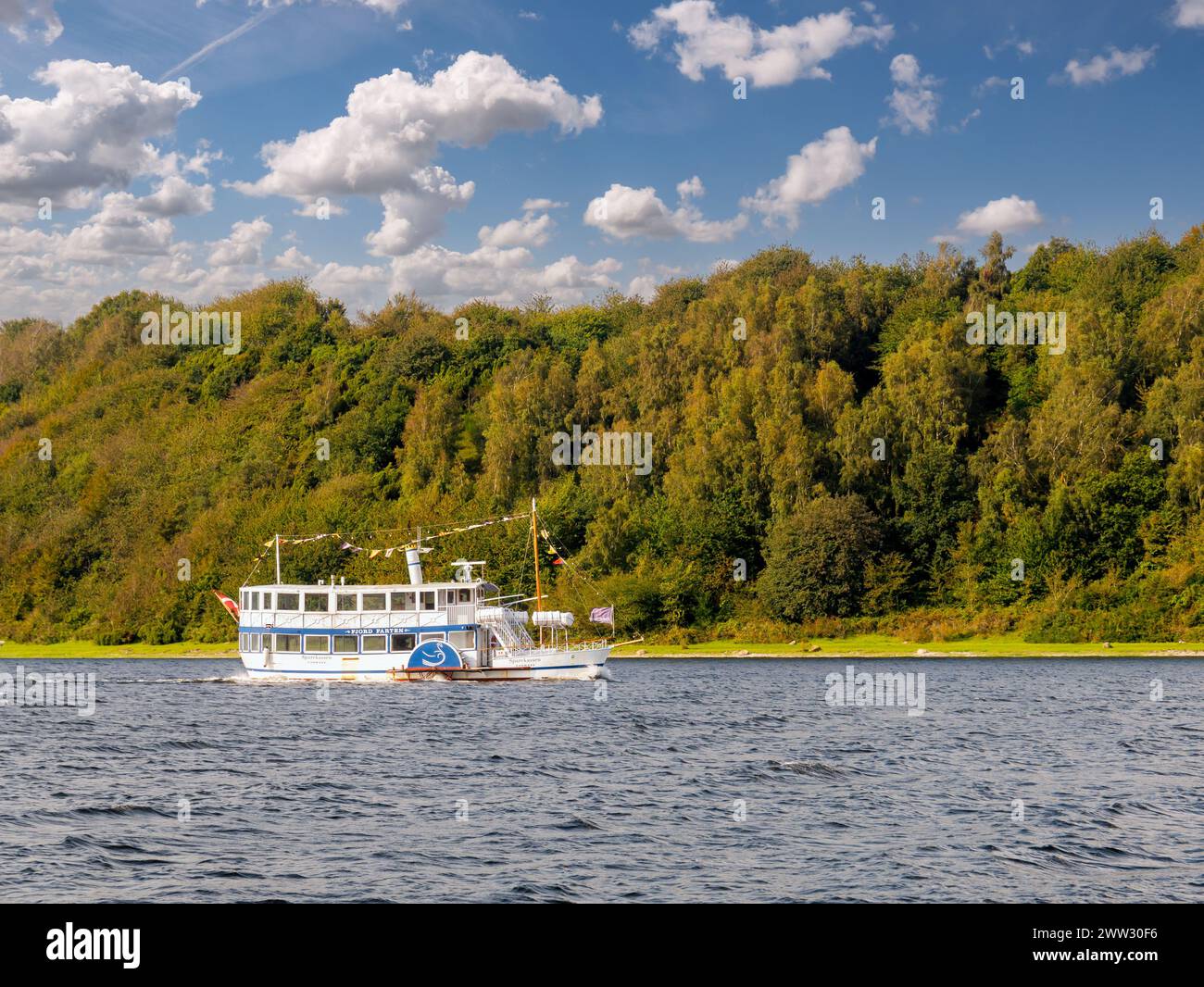 Bateau à aubes Svanen naviguant sur le fjord Mariager le long des collines boisées en automne, Himmerland, Nordjylland, Danemark Banque D'Images