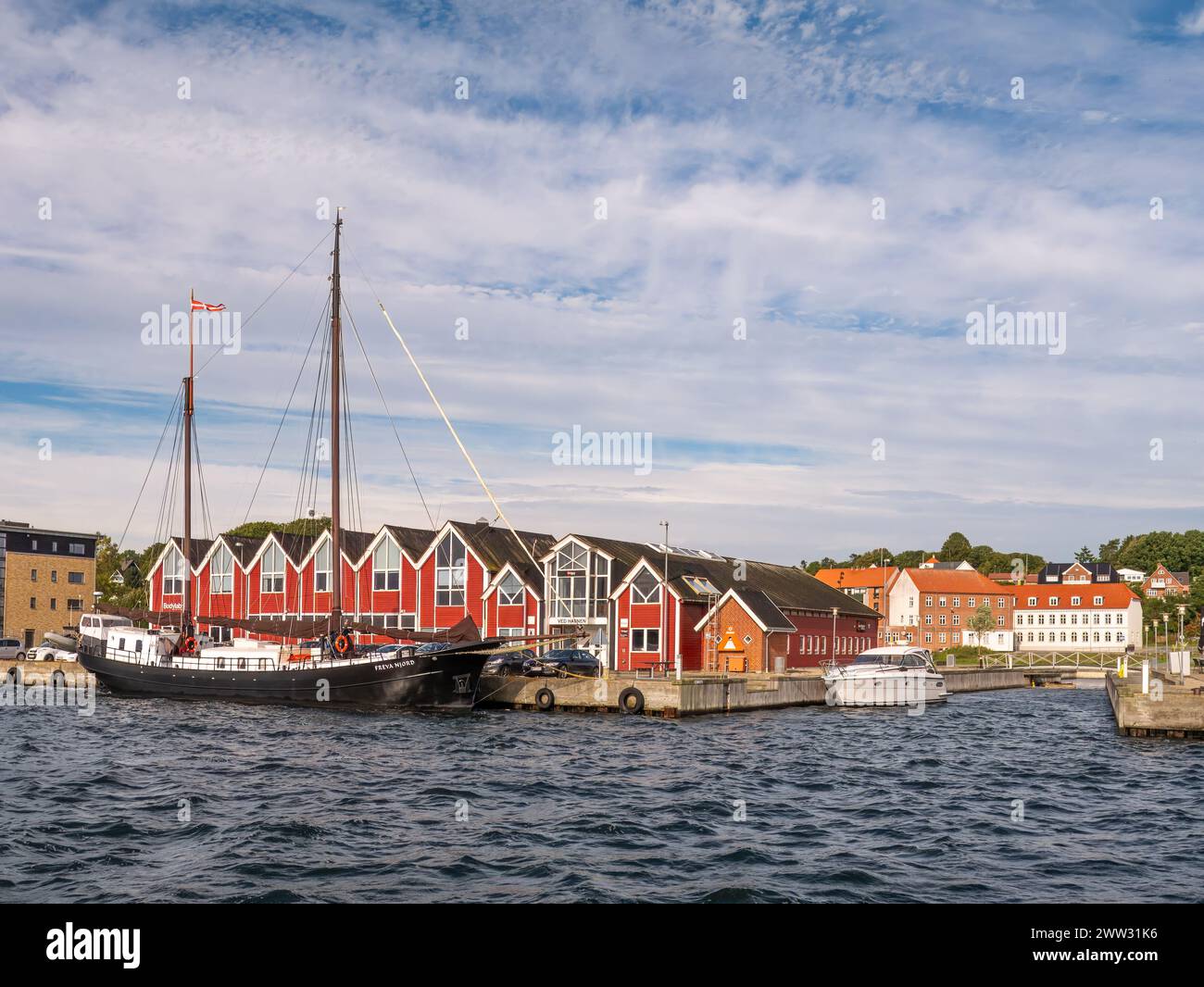 Voilier et bloc de bureaux de couleur rouge le long de Mariagerfjord, Hadsund, Himmerland, Nordjylland, Danemark Banque D'Images