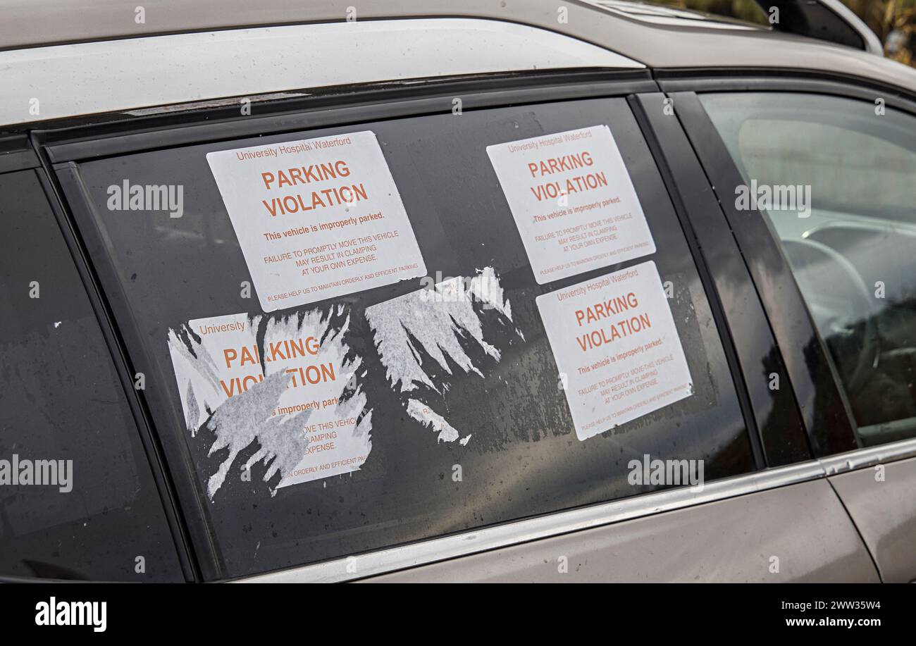 Autocollants de violation de stationnement sur la vitre de la voiture avec menace de serrage, Irlande Banque D'Images