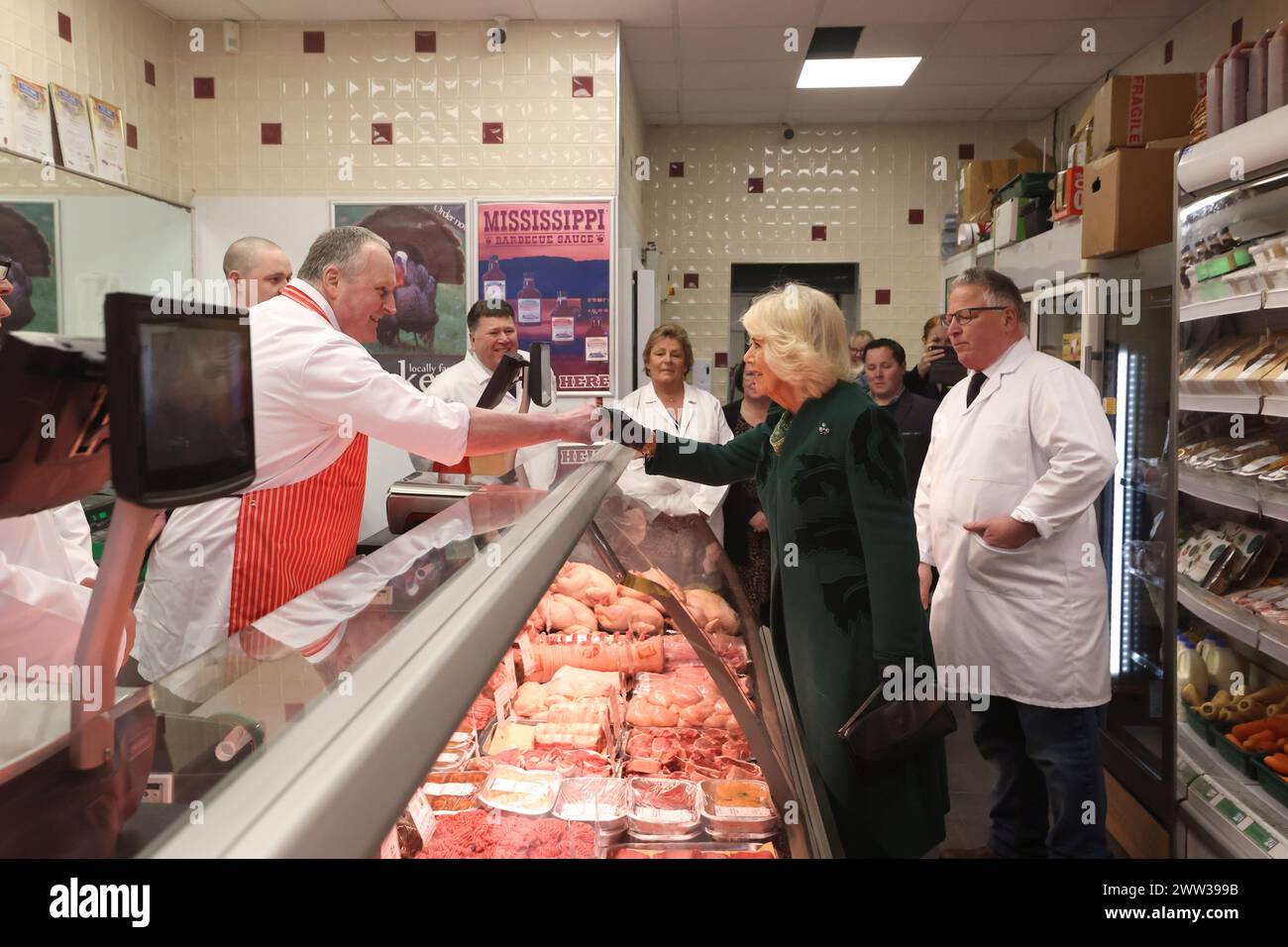 La reine Camilla rencontre le personnel de Coffey's Butchers lors d'une visite à Lisburn Road à Belfast pour rencontrer les propriétaires de magasins et le personnel, et en apprendre davantage sur leur contribution positive à la communauté, lors de sa visite officielle de deux jours en Irlande du Nord. Date de la photo : jeudi 21 mars 2024. Banque D'Images