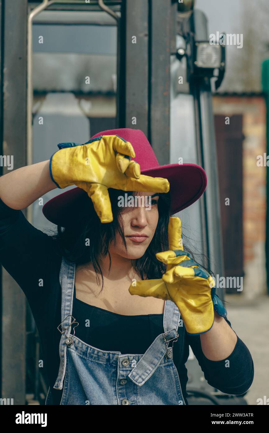 Femme en vêtements de travail protecteurs faisant une expression sérieuse avec ses mains Banque D'Images