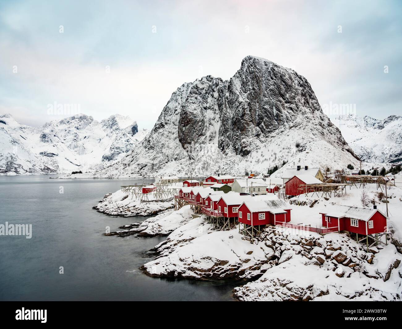 Cabanes Rorbuer de Hamnoy au fjord, montagnes enneigées en arrière-plan, Hamnoy, Reine, Moskenesoya, Lofoten, Norvège Banque D'Images