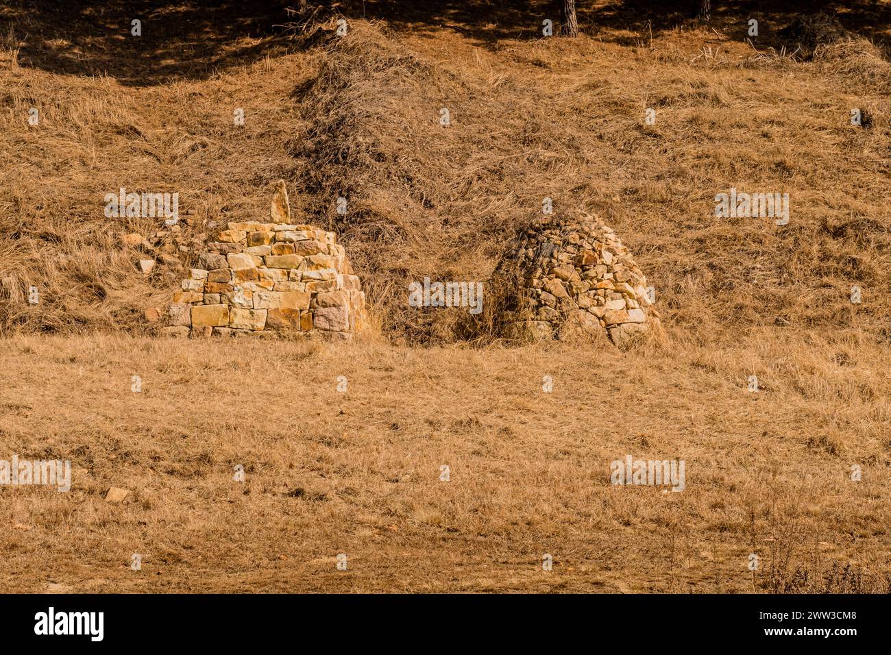 Deux structures rocheuses en forme de pyramide dans un champ d'herbe brune au pied d'une colline à Boeun, Corée du Sud Banque D'Images