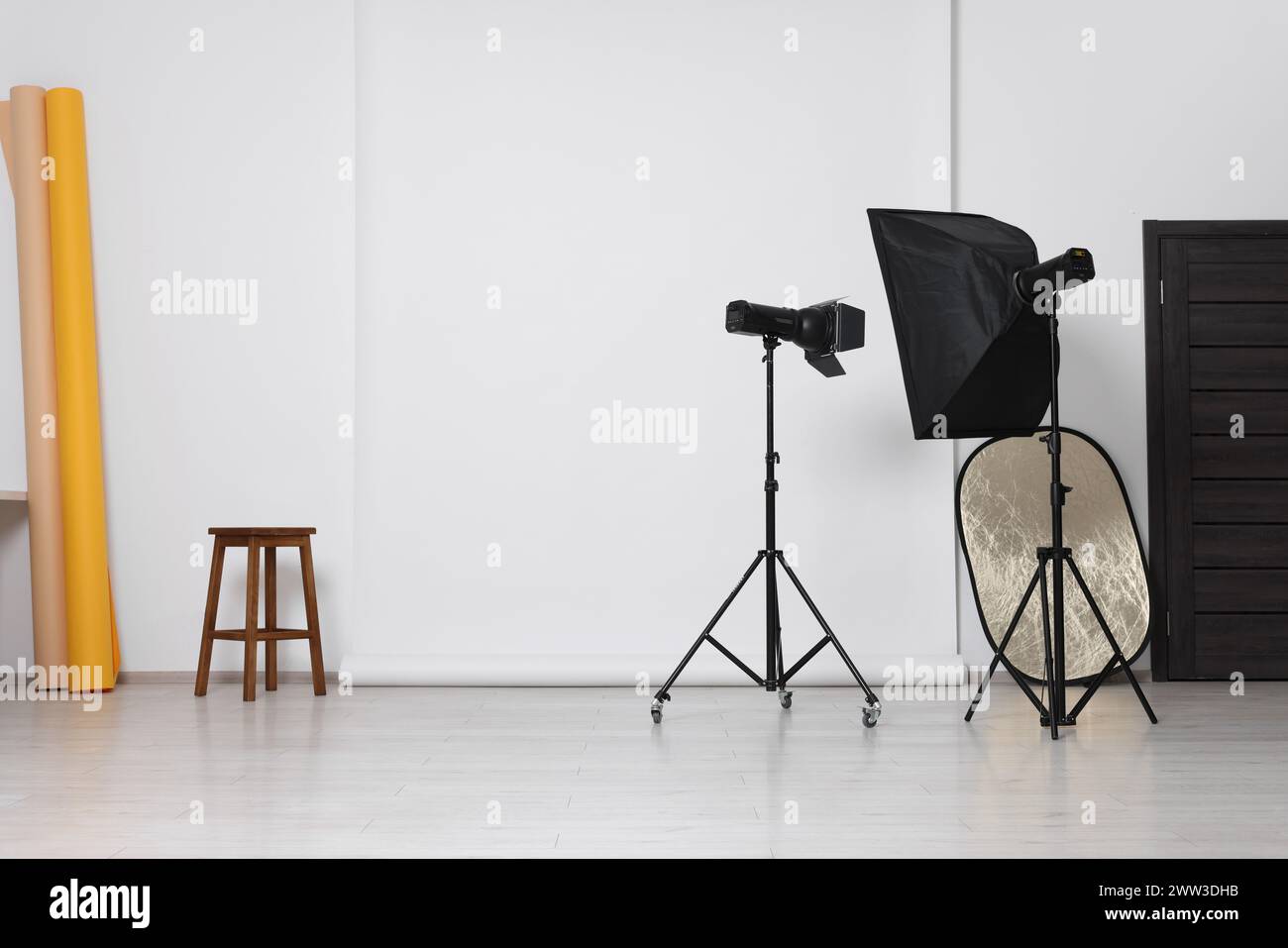 Différents fonds de photo, tabouret et équipement d'éclairage professionnel en studio Banque D'Images