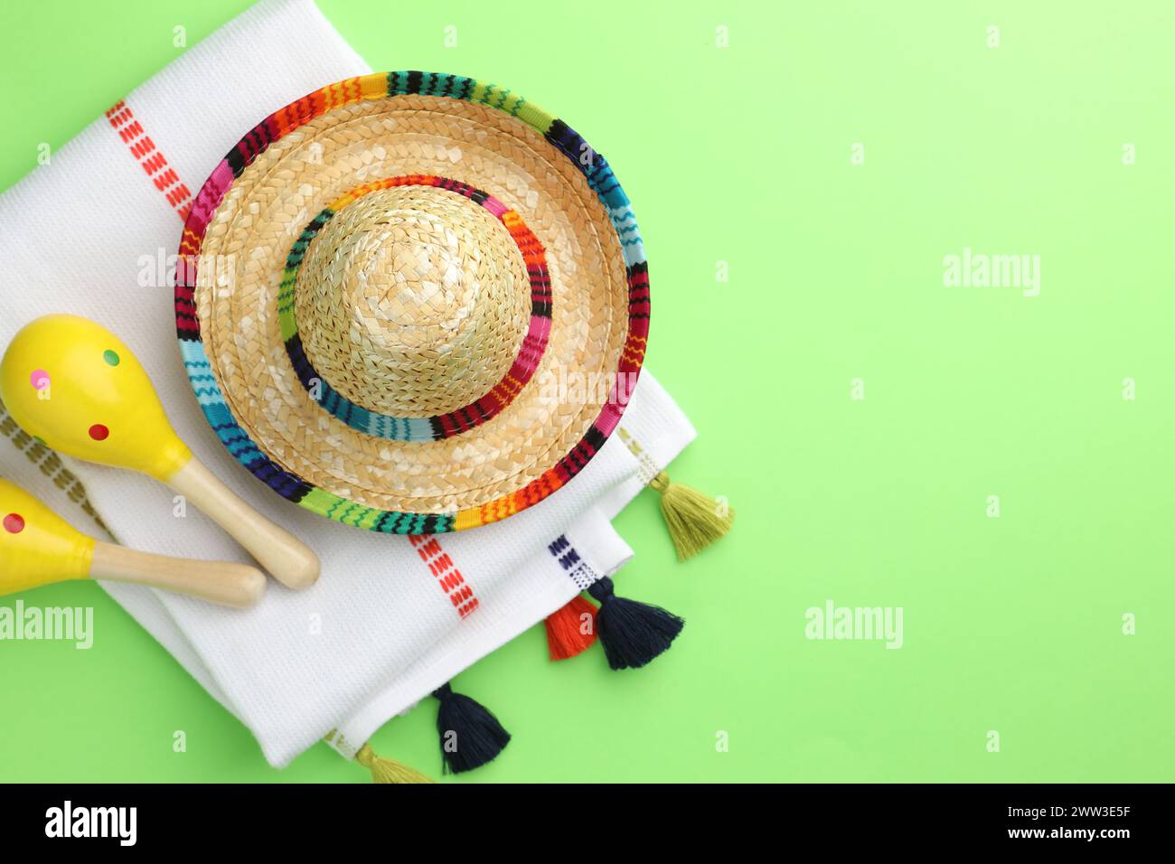 Chapeau sombrero mexicain, maracas et poncho sur fond vert, plat. Espace pour le texte Banque D'Images