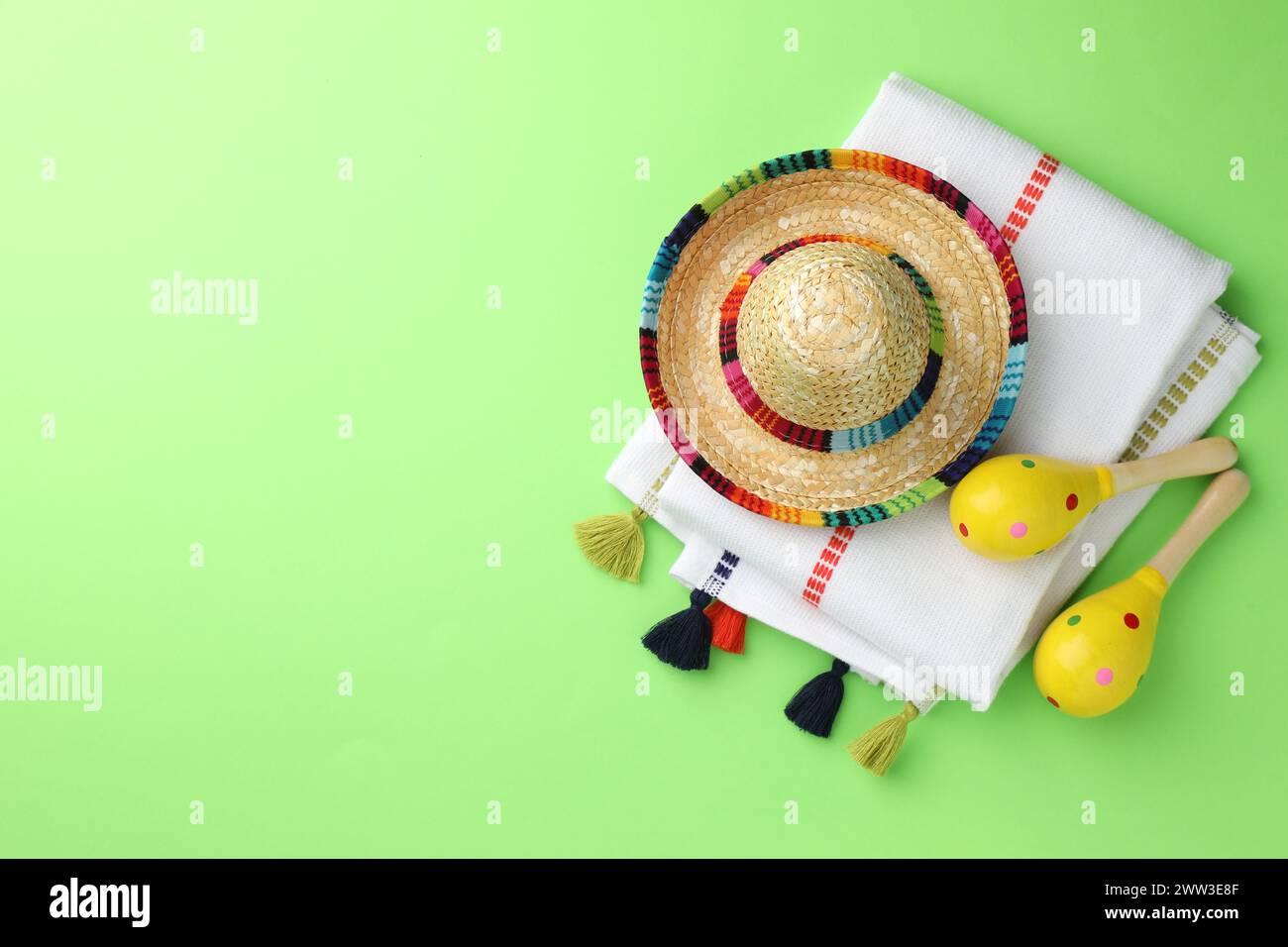 Chapeau sombrero mexicain, maracas et poncho sur fond vert, plat. Espace pour le texte Banque D'Images