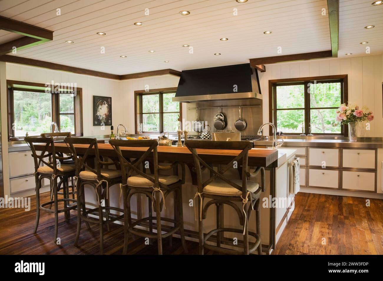 Cuisine de style campagnard avec îlot et chaises hautes en bois rustiques à l'intérieur de la maison de style New Hampton, Québec, Canada Banque D'Images