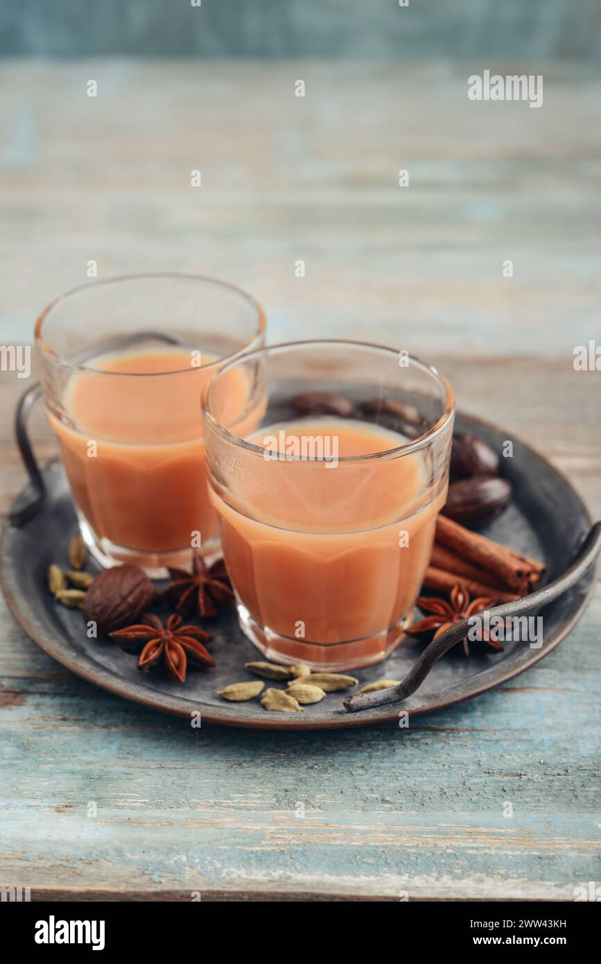 Boisson indienne traditionnelle - thé masala avec des épices sur plateau en métal sur fond en bois Banque D'Images