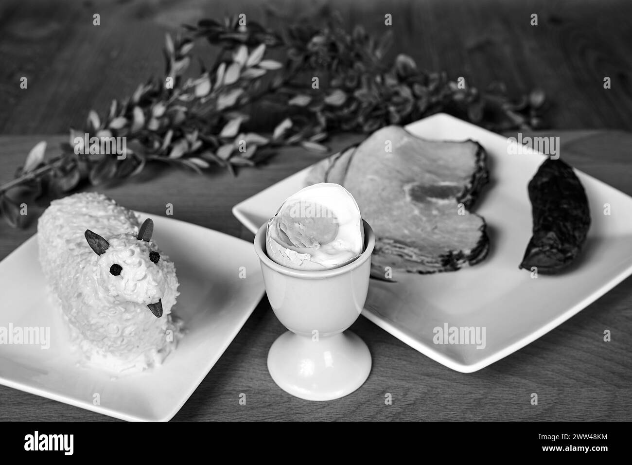 Plats traditionnels pour le petit déjeuner de Pâques et l'agneau au beurre sur la table en bois en Pologne, monochrome Banque D'Images