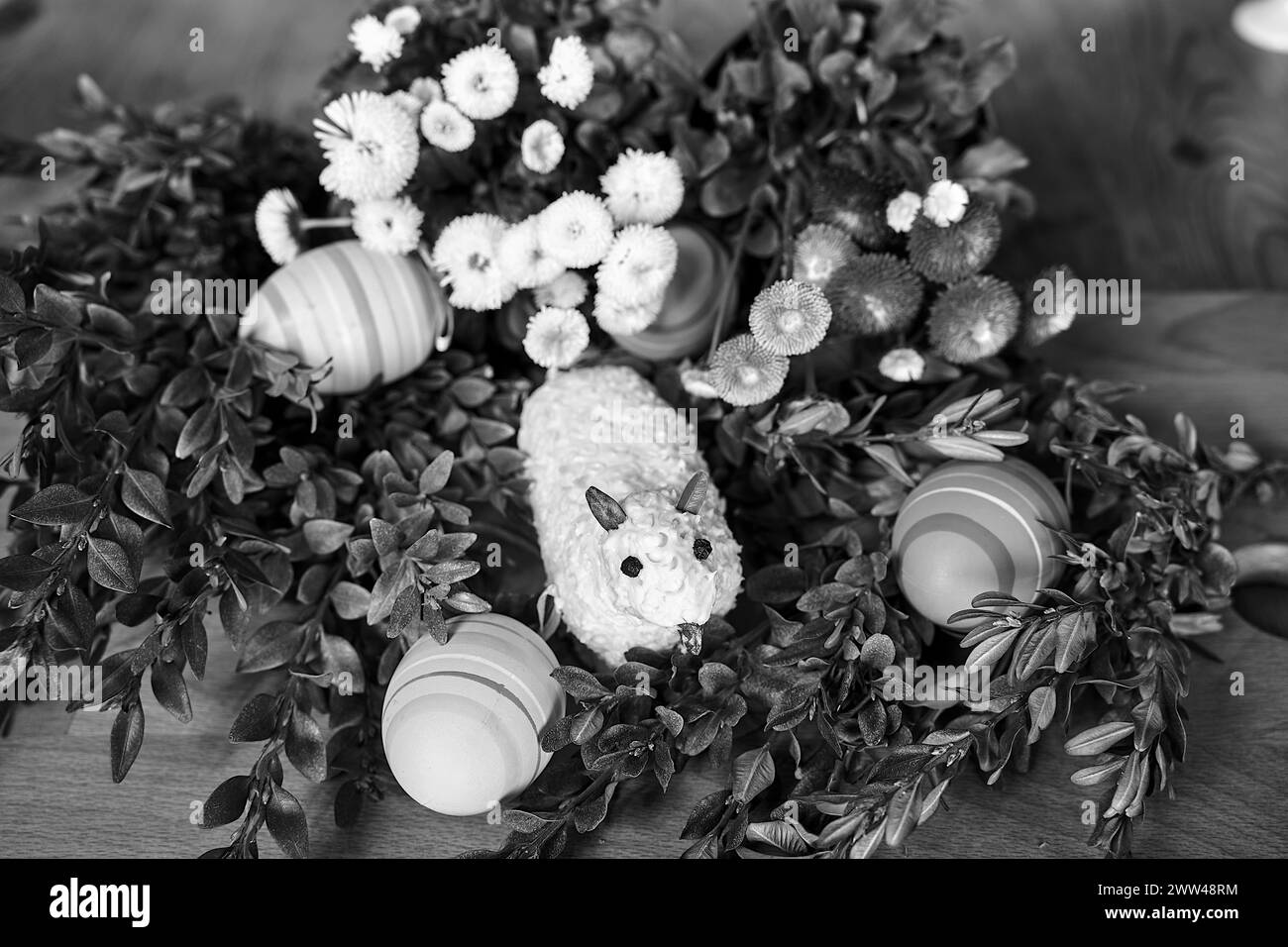 Agneau de Pâques traditionnel fait de beurre, brindilles de buis, œufs peints et fleurs printanières colorées en Pologne, monochrome Banque D'Images