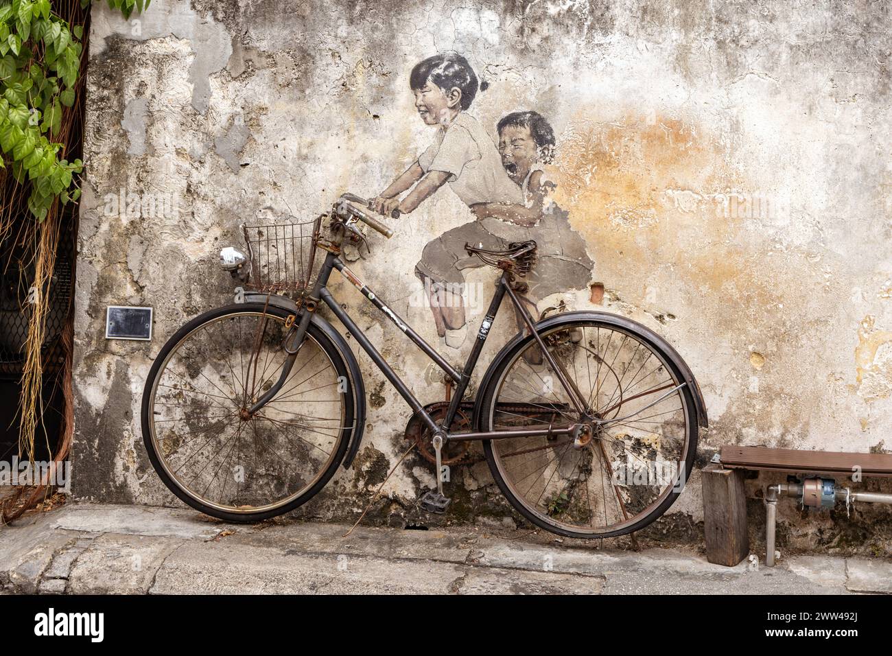 Petits enfants sur une peinture murale à vélo sur Armenian Street, George Town, Penang par l'artiste lituanien Ernest Zacharevic. Banque D'Images