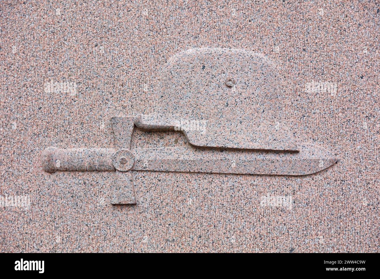 Un dessin d'épée et de casque gravé sur la pierre tombale dans le cimetière. Banque D'Images