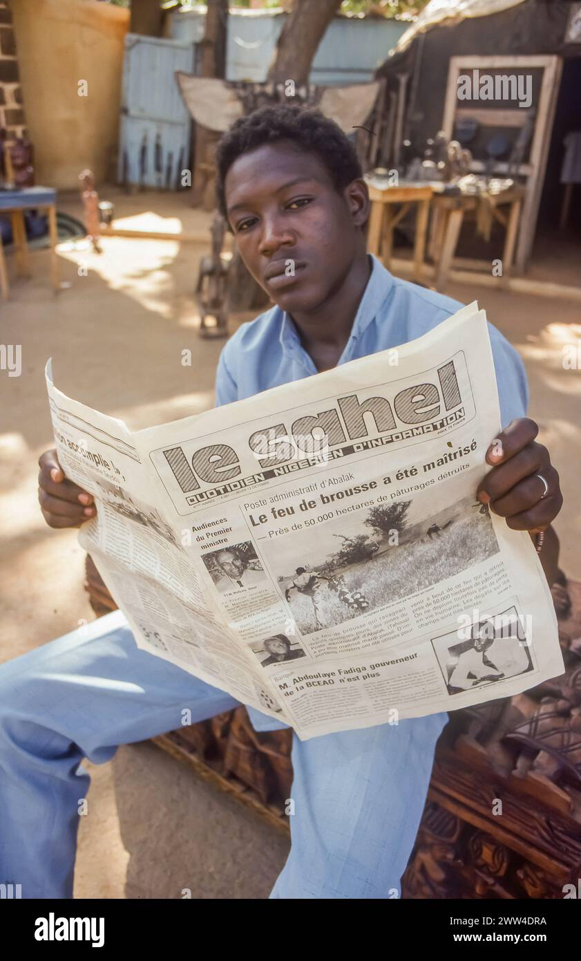 Niger, Niamey, l'homme lit le journal 'le Sahel'. Banque D'Images