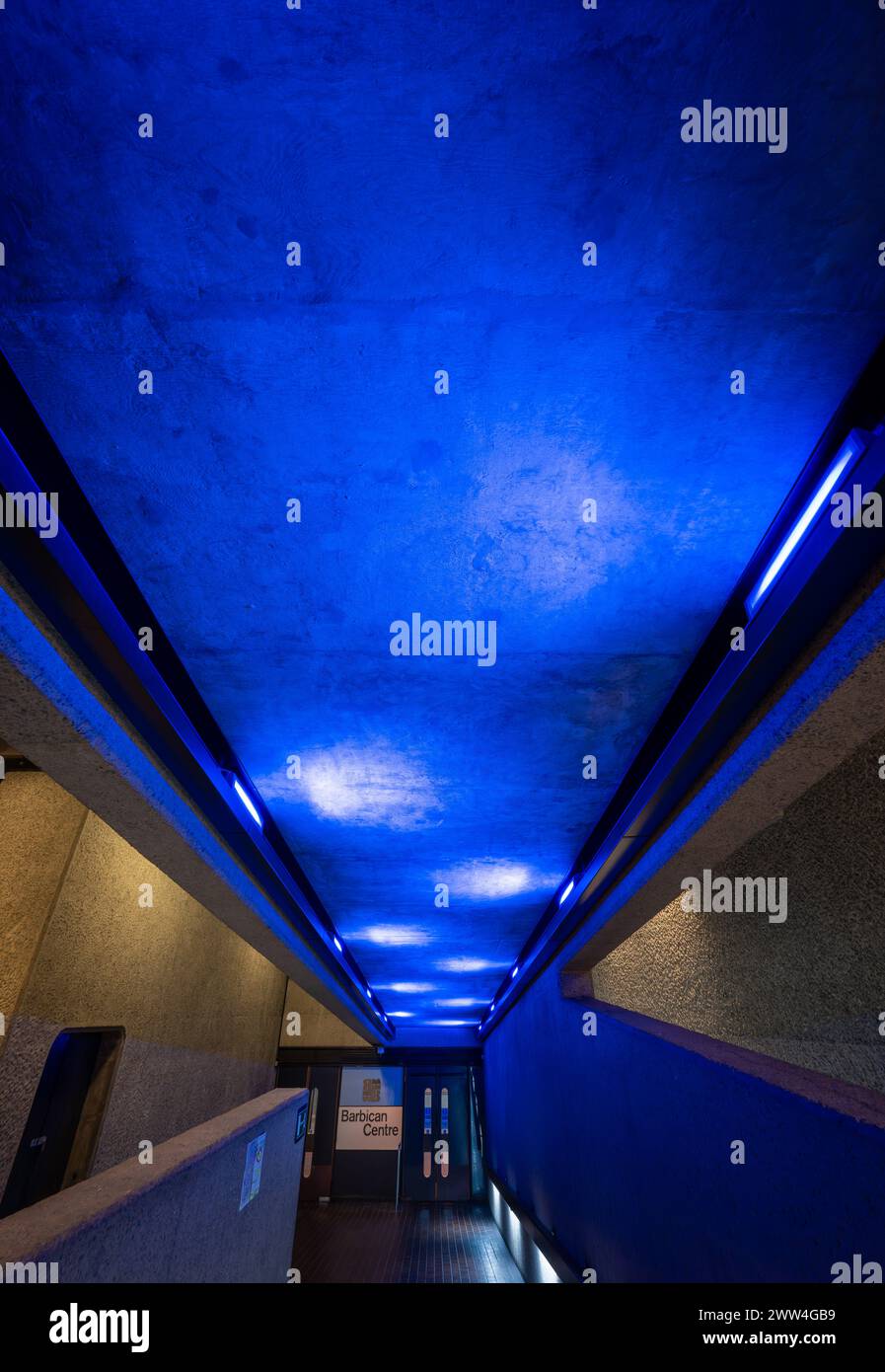 Londres, Royaume-Uni : architecture intérieure du domaine Barbican dans la ville de Londres avec rampe d'accès et lumières bleues. Banque D'Images