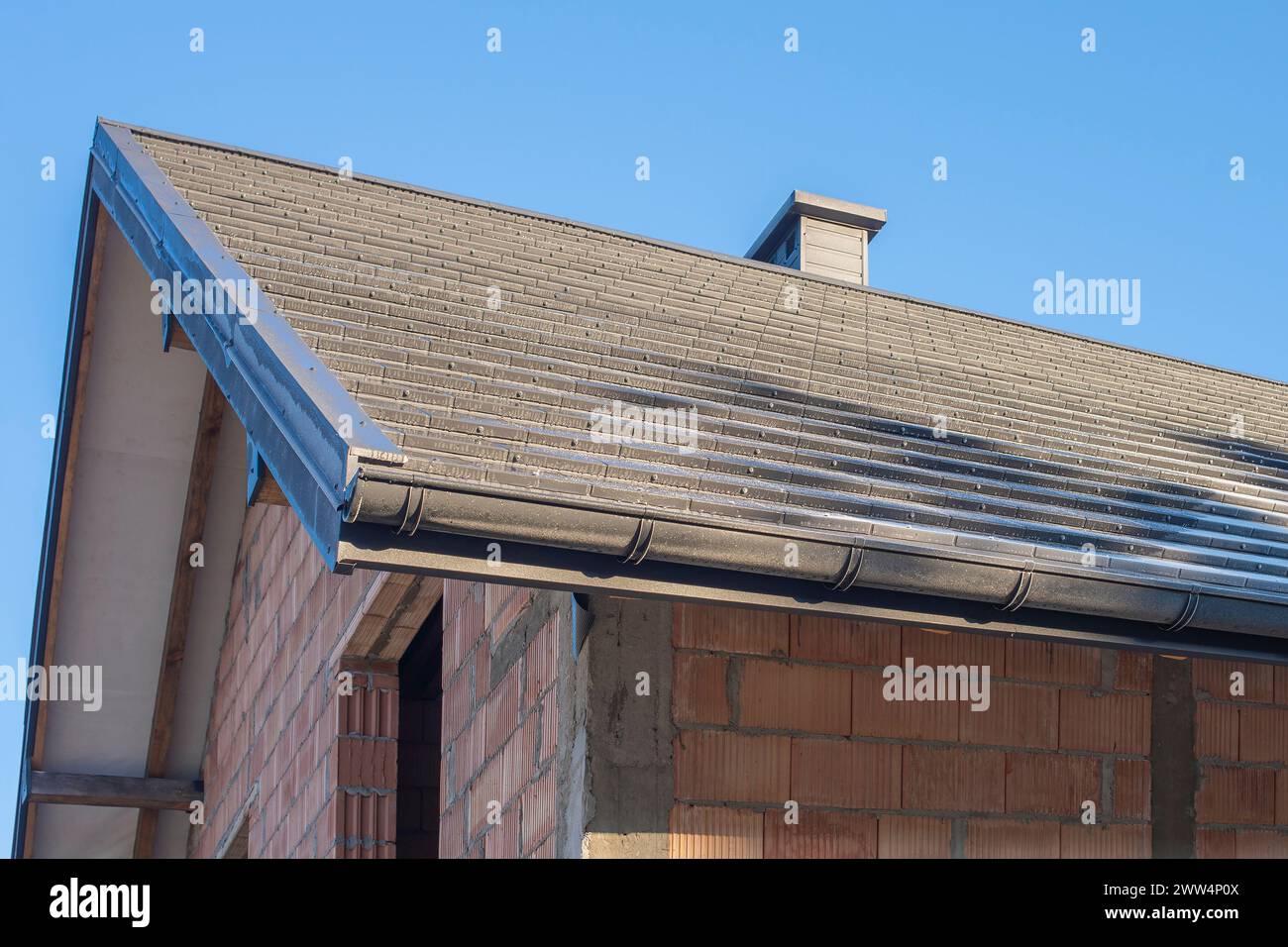 Le toit de couleur anthracite d'une nouvelle maison résidentielle contre le ciel bleu Banque D'Images