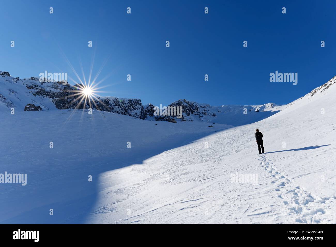 Un alpiniste marchant sur les montagnes. Belle journée ensoleillée pour randonnée hivernale en plein air. Voyages hivernaux. Aventure. Vue panoramique Banque D'Images