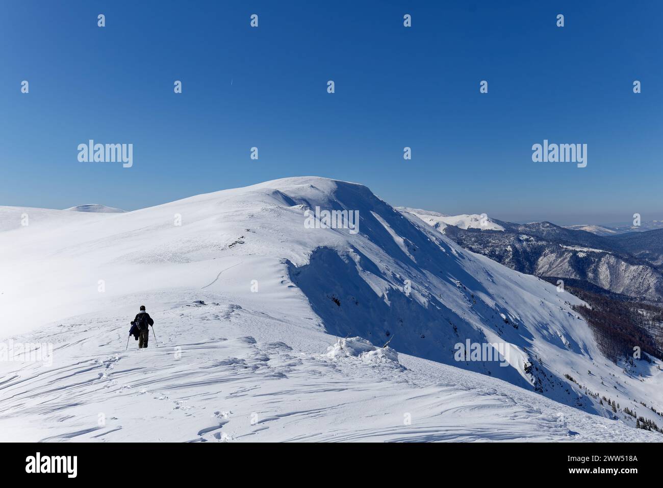 Une femme alpiniste faisant de la raquette dans les montagnes. Belle journée ensoleillée pour randonnée hivernale en plein air. Voyages hivernaux. Aventure. Vue panoramique Banque D'Images