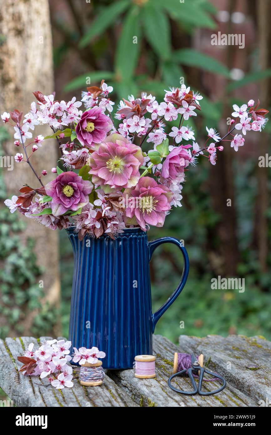 bouquet de roses de carême roses et fleur de prune à feuilles violettes dans un vase Banque D'Images