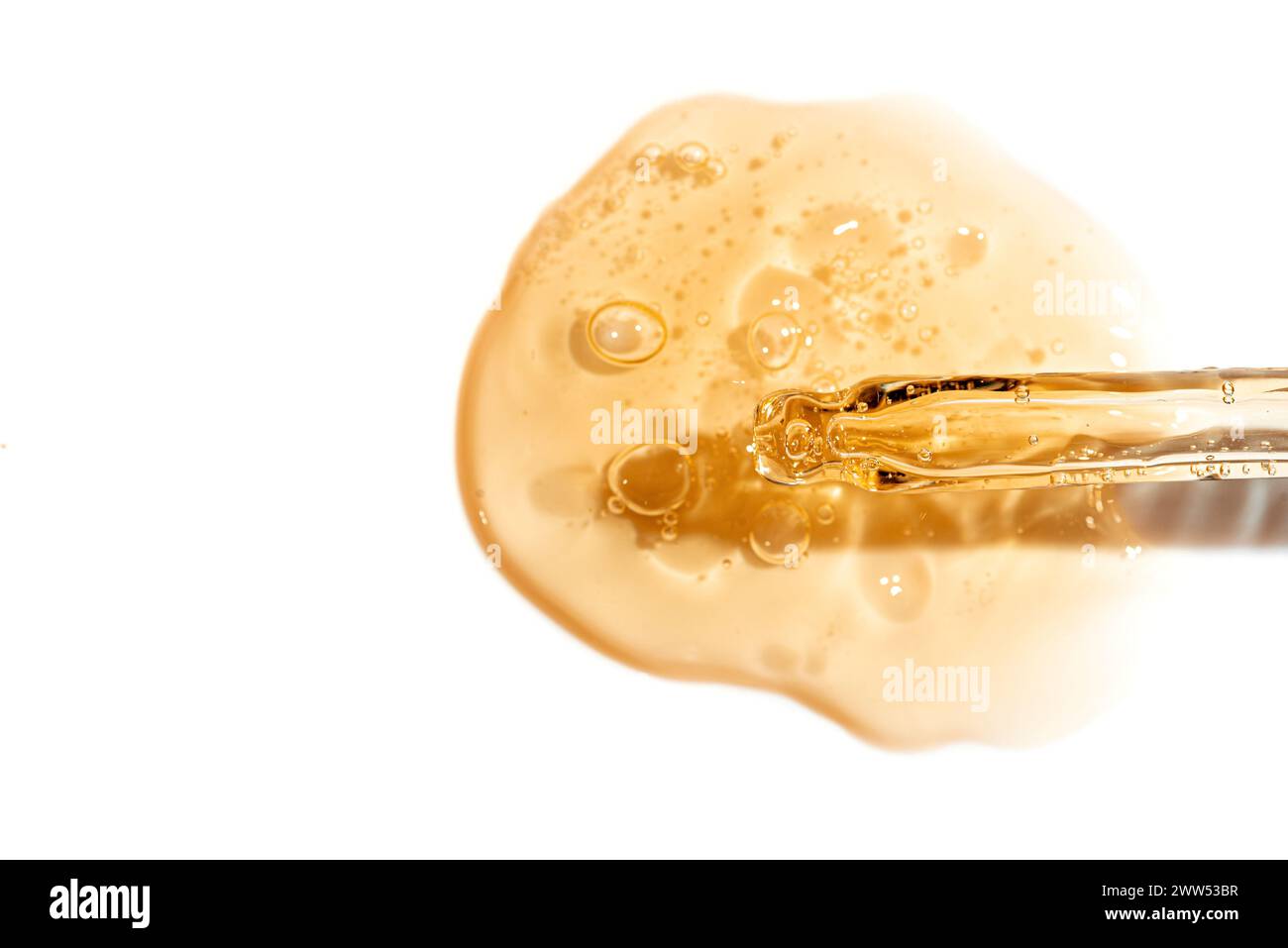 Pipette compte-gouttes et échantillon de sérum doré ou de gel de rétinol isolé sur fond blanc. Soin de la peau avec huile ou peptide. Échantillon de texture de cosmétique Banque D'Images