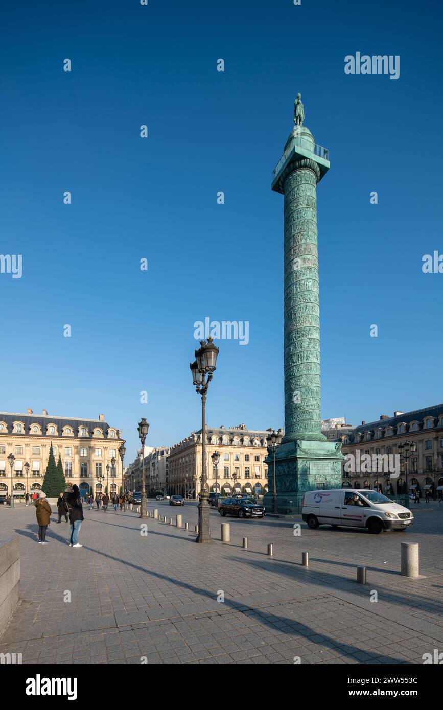 Piétons marchant près de la colonne Vendôme sous un ciel bleu clair. Banque D'Images