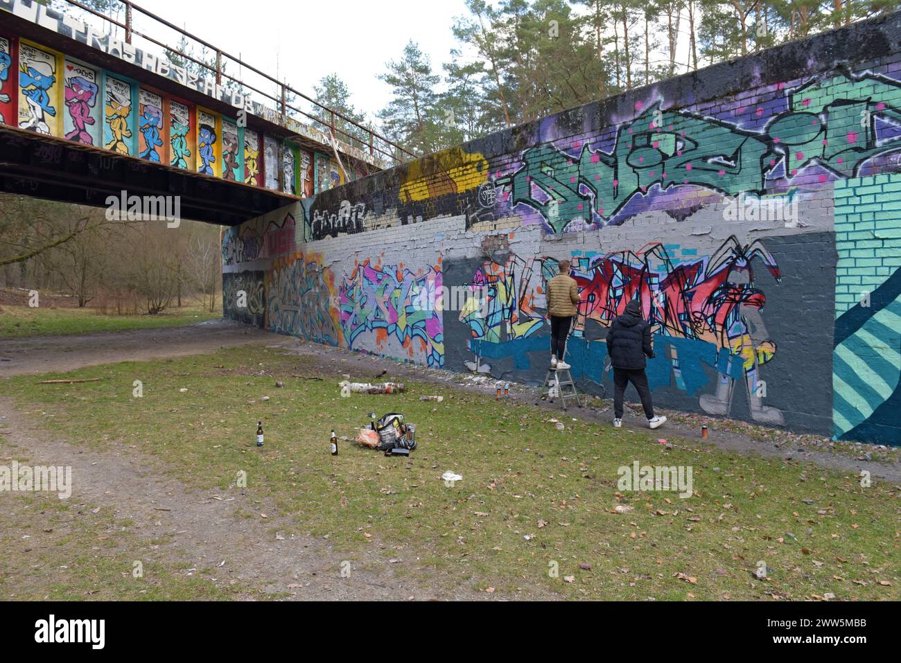 Artistes de rue peignant des graffitis d'art de rue sur le pont Stammbahn, un ancien pont désaffecté de la ligne de chemin de fer S Bahn à Kleinmachnow, Berlin, Allemagne Banque D'Images