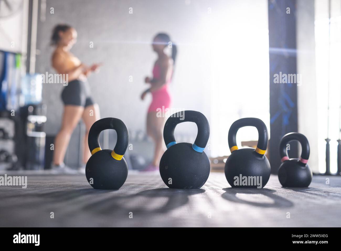 Kettlebells attendent l'utilisation avec l'espace de copie comme un entraîneur de gymnastique caucasien instruit son stagiaire Banque D'Images