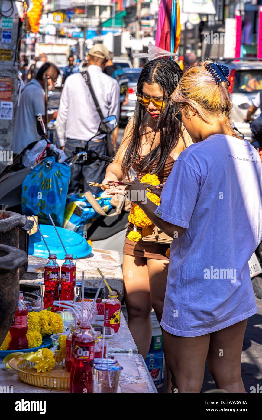 Filles faisant l'offrande bouddhiste à Spirit House sur soi Buakhao, Pattaya, Thaïlande Banque D'Images