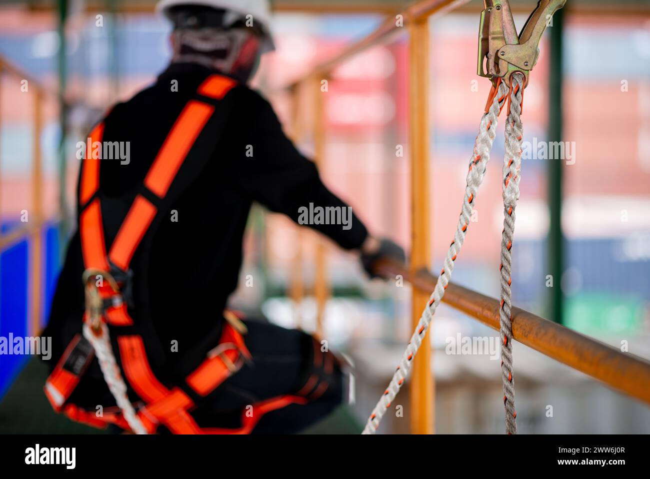 Travailleur de la construction portant un harnais de sécurité et une ligne de sécurité travaillant à endroit élevé Banque D'Images