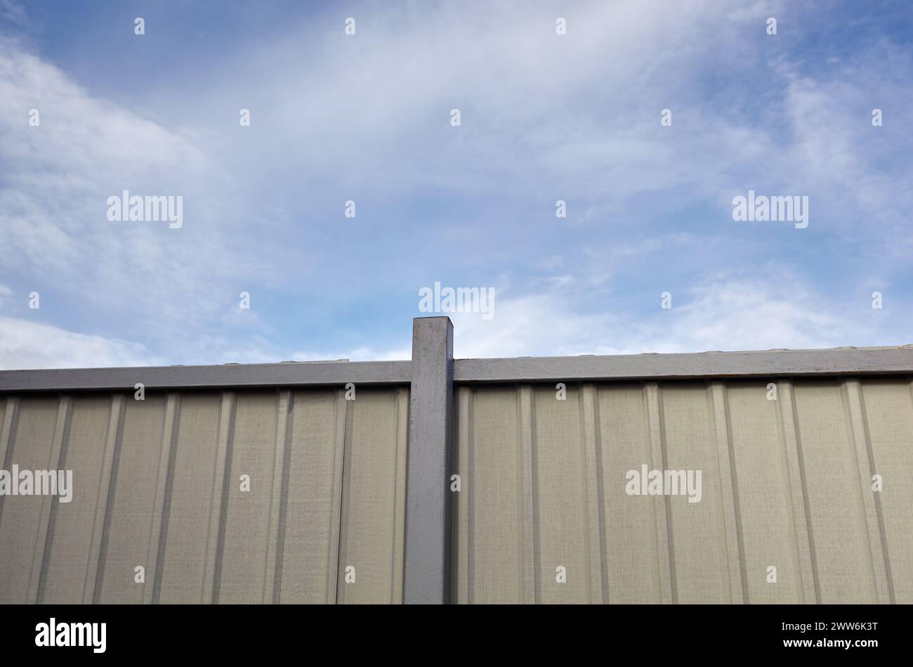 Clôture en acier ondulé contre le ciel bleu. Surface de texture métallique ondulée ou galvaniser l'acier Banque D'Images
