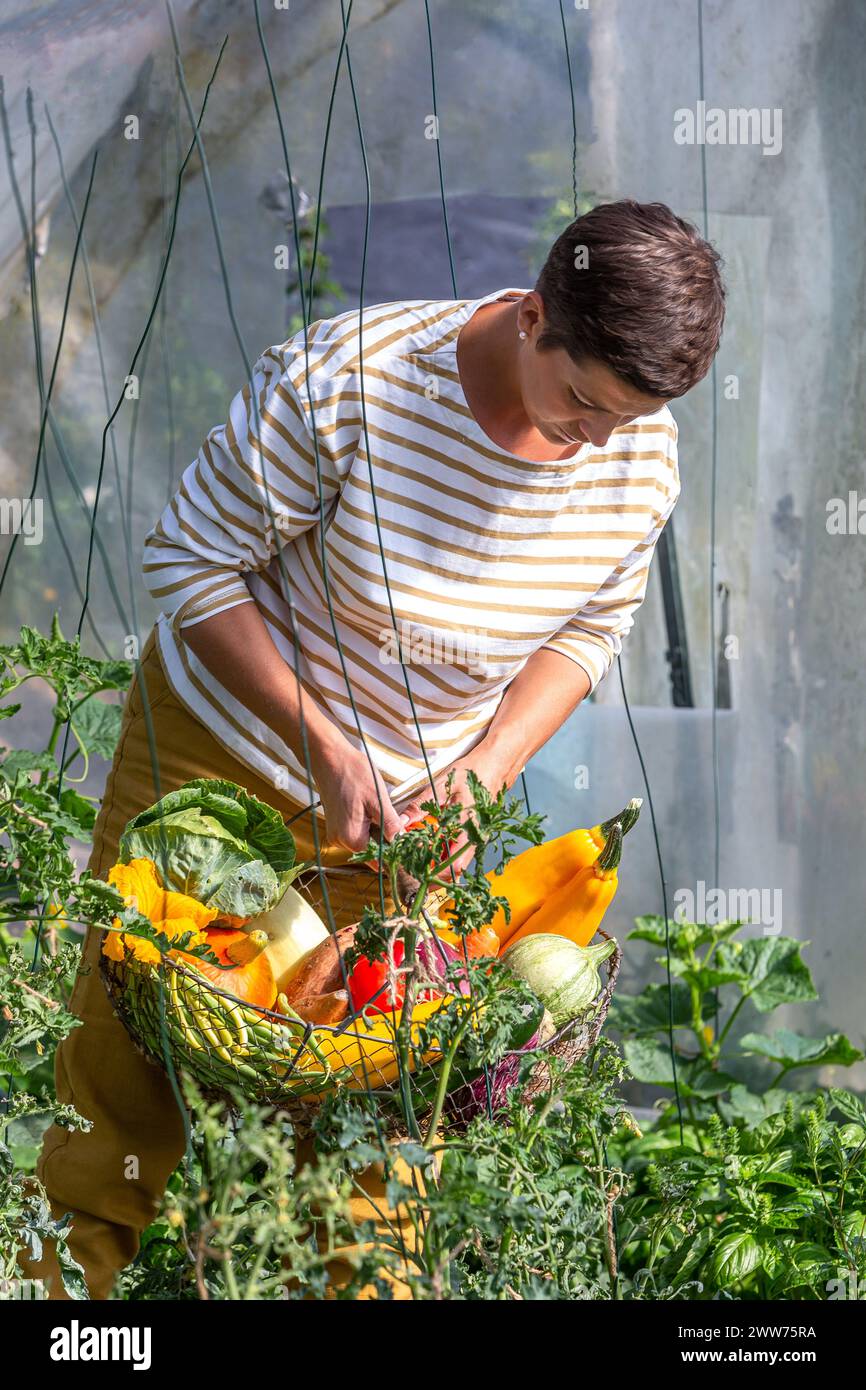 Jeune femme debout le panier rempli de légumes. Banque D'Images