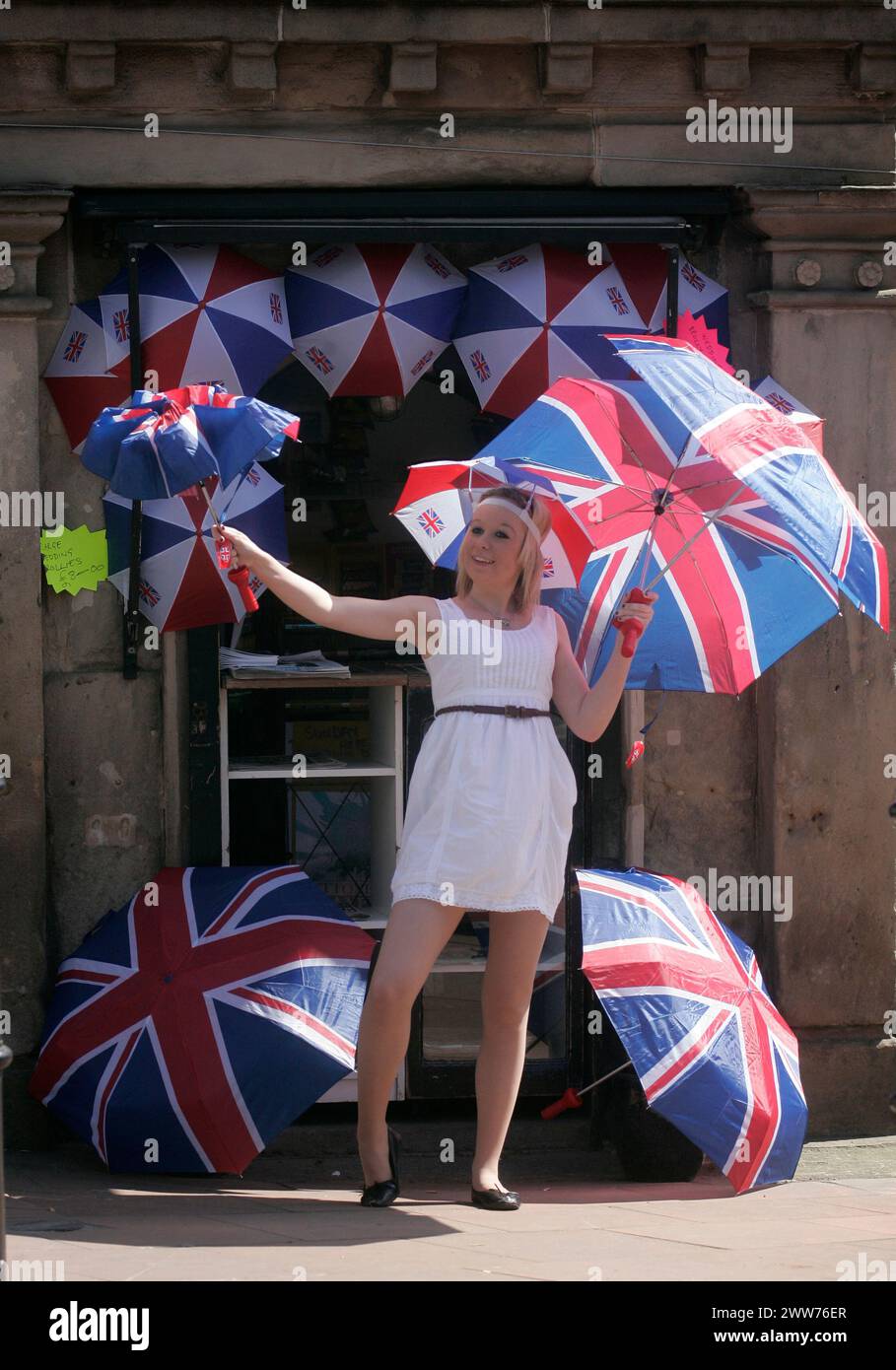 27/04/11. ..avec une probabilité de 60% de prévisions de pluie pour vendredi, Sarah Bean (20 ans) a une journée chargée au soleil vendant des parapluies union jack à Utto Banque D'Images