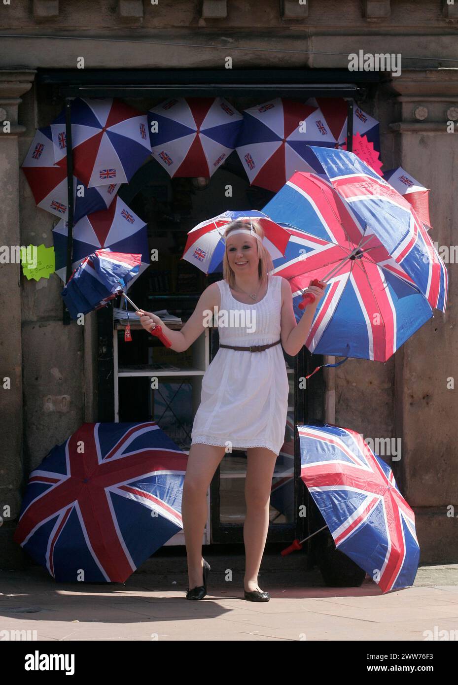 27/04/11. ..avec une probabilité de 60% de prévisions de pluie pour vendredi, Sarah Bean (20 ans) a une journée chargée au soleil vendant des parapluies union jack à Utto Banque D'Images