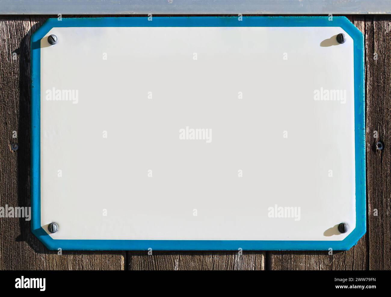 collage, émail, métal ou signe de poterie sur un mur rustique en bois. cadre bleu. le soleil brille, dalle de pierre rectangulaire avec espace de copie pour écrire, rétro Banque D'Images