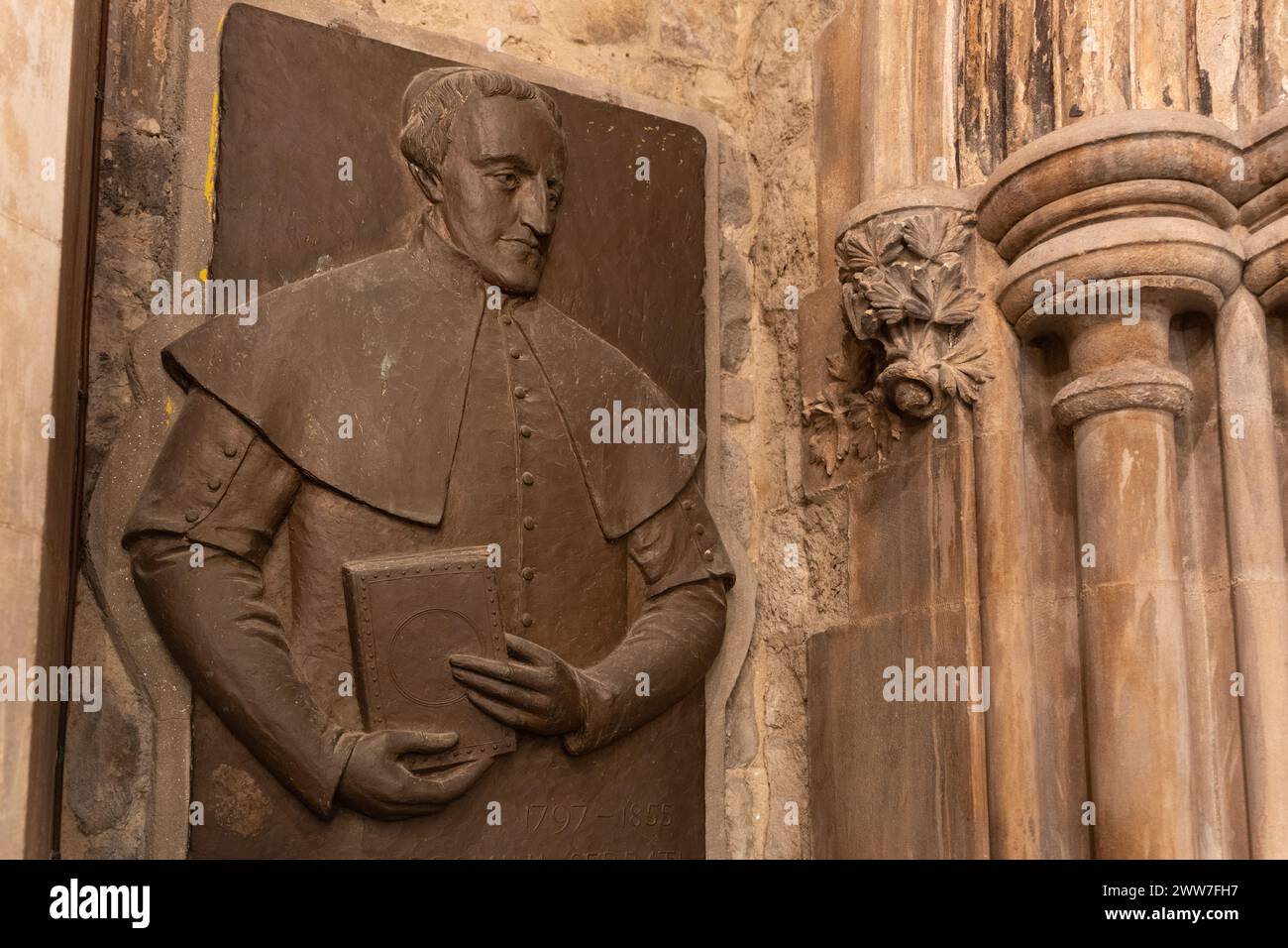 Une plaque de bronze commémorant une figure importante au sein de l'église. Le détail de la sculpture est impressionnant Banque D'Images
