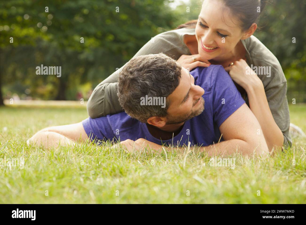 Smiling Couple Lying on Grass Banque D'Images