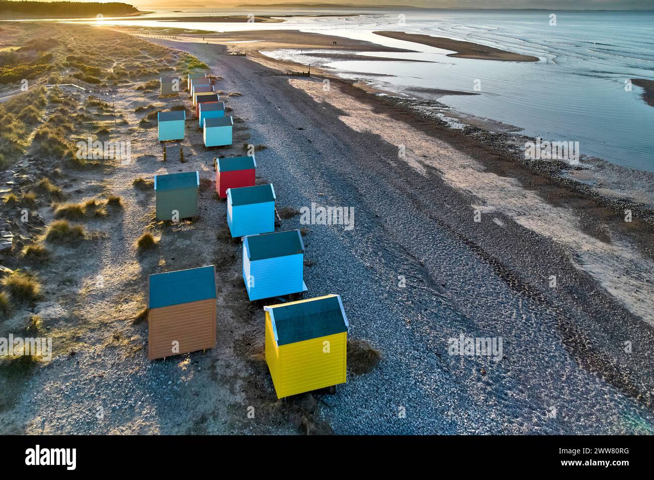 Findhorn Moray Coast Scotland un soleil couchant et une rangée de cabanes de plage colorées regardant vers l'île Noire Banque D'Images
