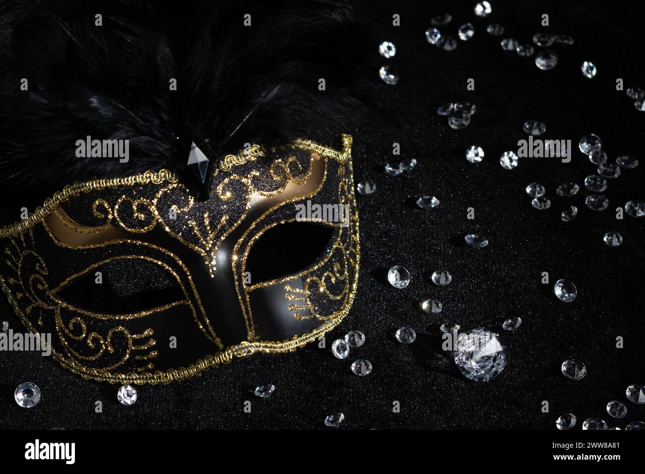Vue rapprochée du masque d'or de carnaval avec des diamants sur fond noir. Banque D'Images