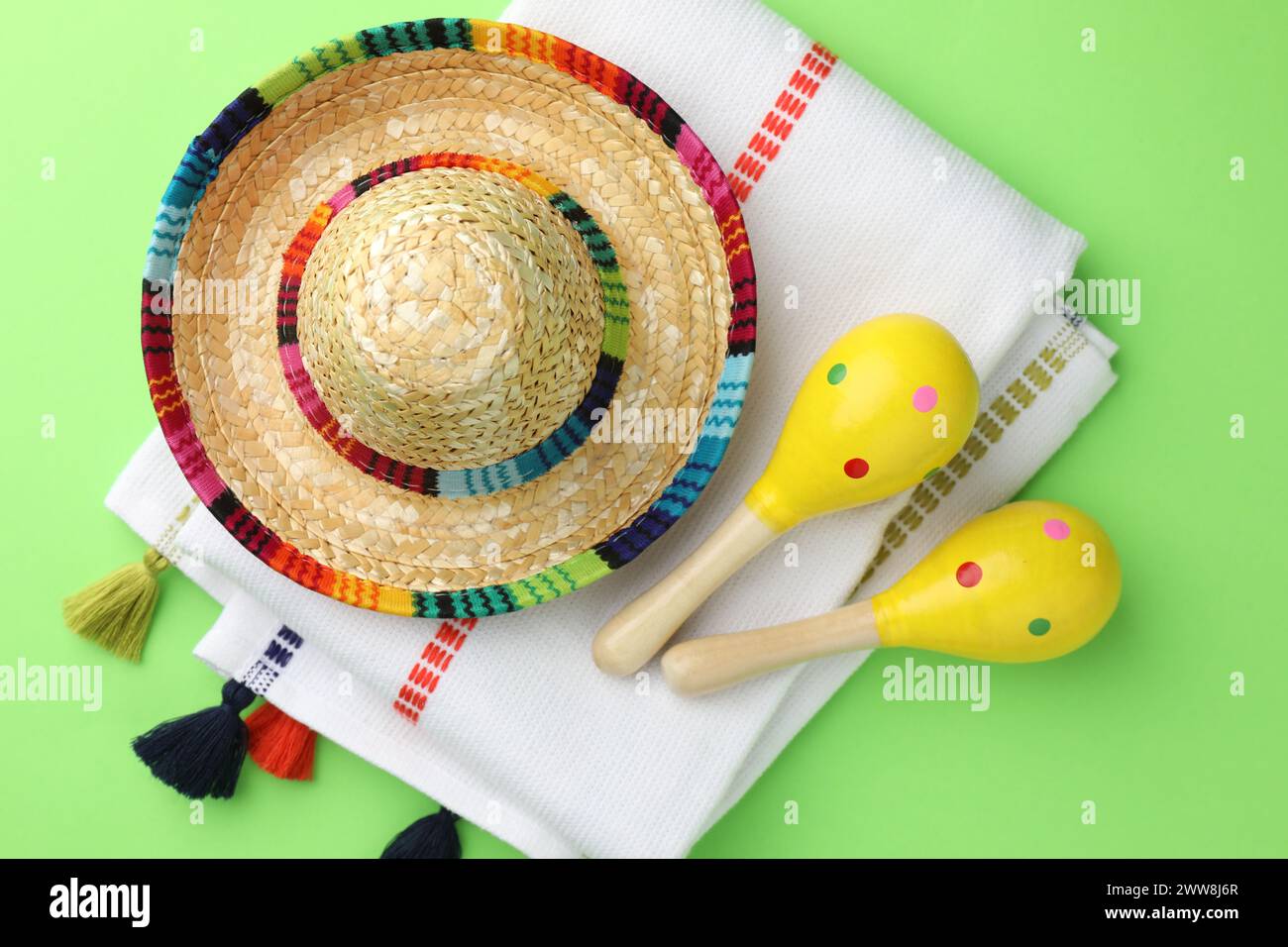 Chapeau sombrero mexicain, maracas et poncho sur fond vert, plat Banque D'Images