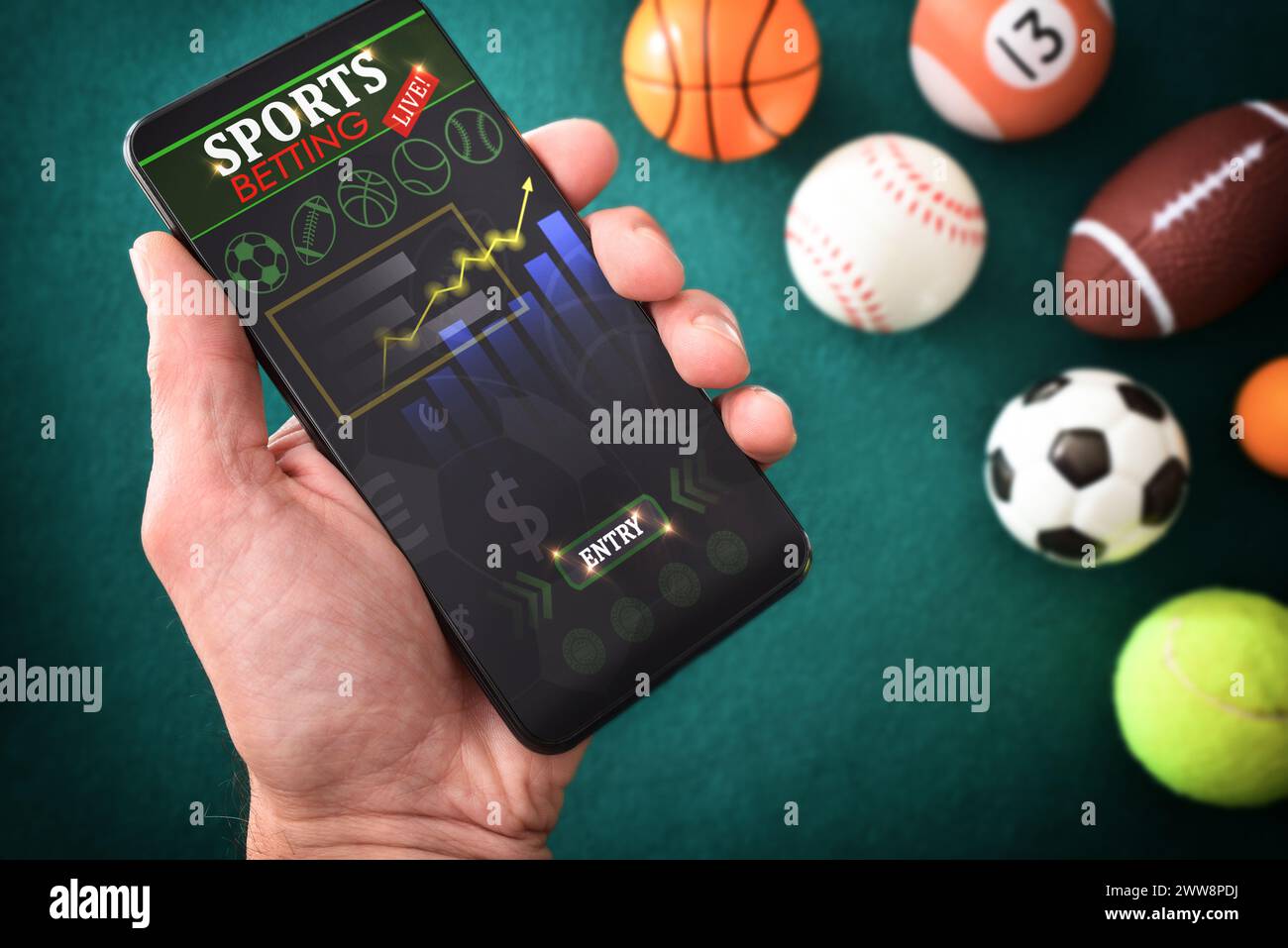 Personne consultant des informations sportives en ligne dans une application sur un smartphone sur une table avec un tapis de feutre vert avec des objets représentatifs de différents sports Banque D'Images