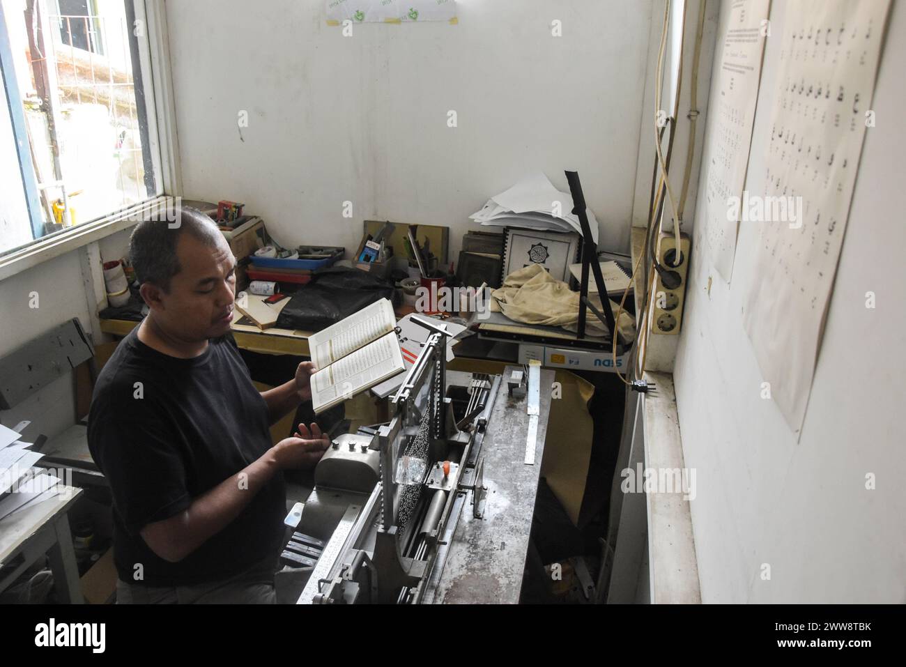 Bandung, Java occidental, Indonésie. 22 mars 2024. Un homme utilise une machine à écrire en braille pour faire des tirages du Coran braille à la Fondation Wyata Guna Penyantun, à Bandung. Cette machine à écrire, qui utilise une machine d'impression braille de marque Thomson de 1952 donnée par l'auteur américain Helen Keller, est utile pour l'impression de corans braille et est la seule encore en activité en Indonésie. Pendant le mois du Ramadan, la machine à imprimer est capable de produire 200 ensembles de corans braille. Crédit : ZUMA Press, Inc/Alamy Live News Banque D'Images