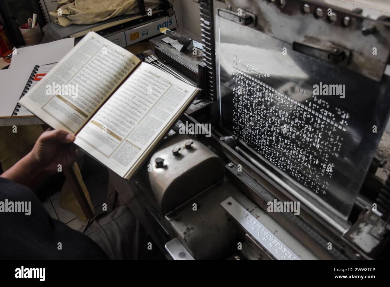 Bandung, Java occidental, Indonésie. 22 mars 2024. Un homme utilise une machine à écrire en braille pour faire des tirages du Coran braille à la Fondation Wyata Guna Penyantun, à Bandung. Cette machine à écrire, qui utilise une machine d'impression braille de marque Thomson de 1952 donnée par l'auteur américain Helen Keller, est utile pour l'impression de corans braille et est la seule encore en activité en Indonésie. Pendant le mois du Ramadan, la machine à imprimer est capable de produire 200 ensembles de corans braille. Crédit : ZUMA Press, Inc/Alamy Live News Banque D'Images
