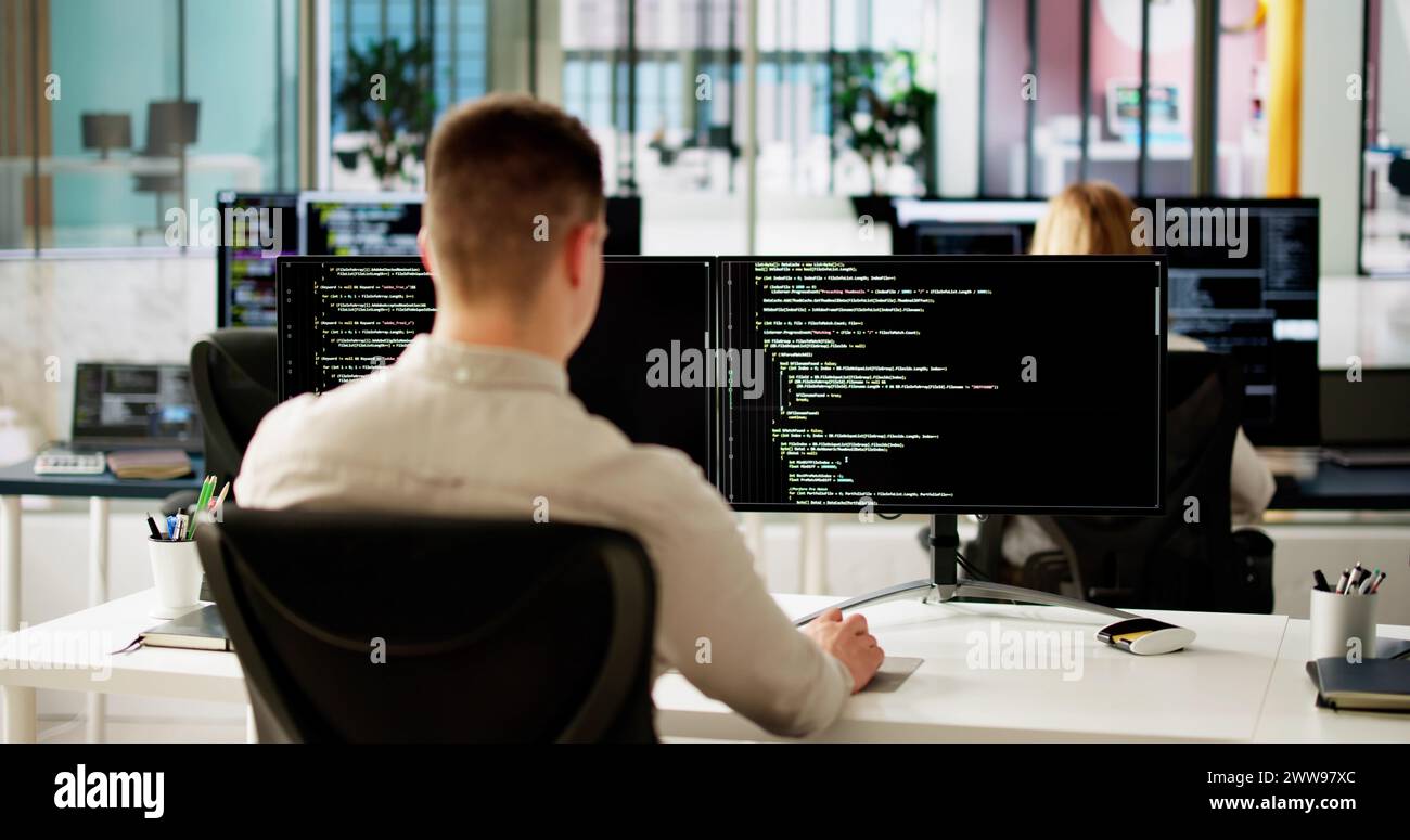 Programmeur de logiciel ou Coder Man utilisant un ordinateur de bureau Banque D'Images