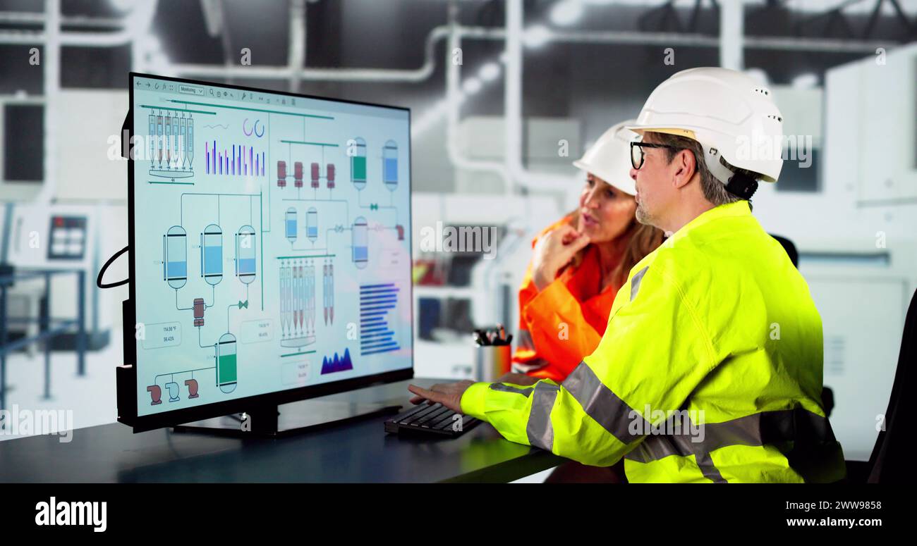 Ingénieur utilisant l'ordinateur dans l'usine d'assemblage de voiture électrique Banque D'Images