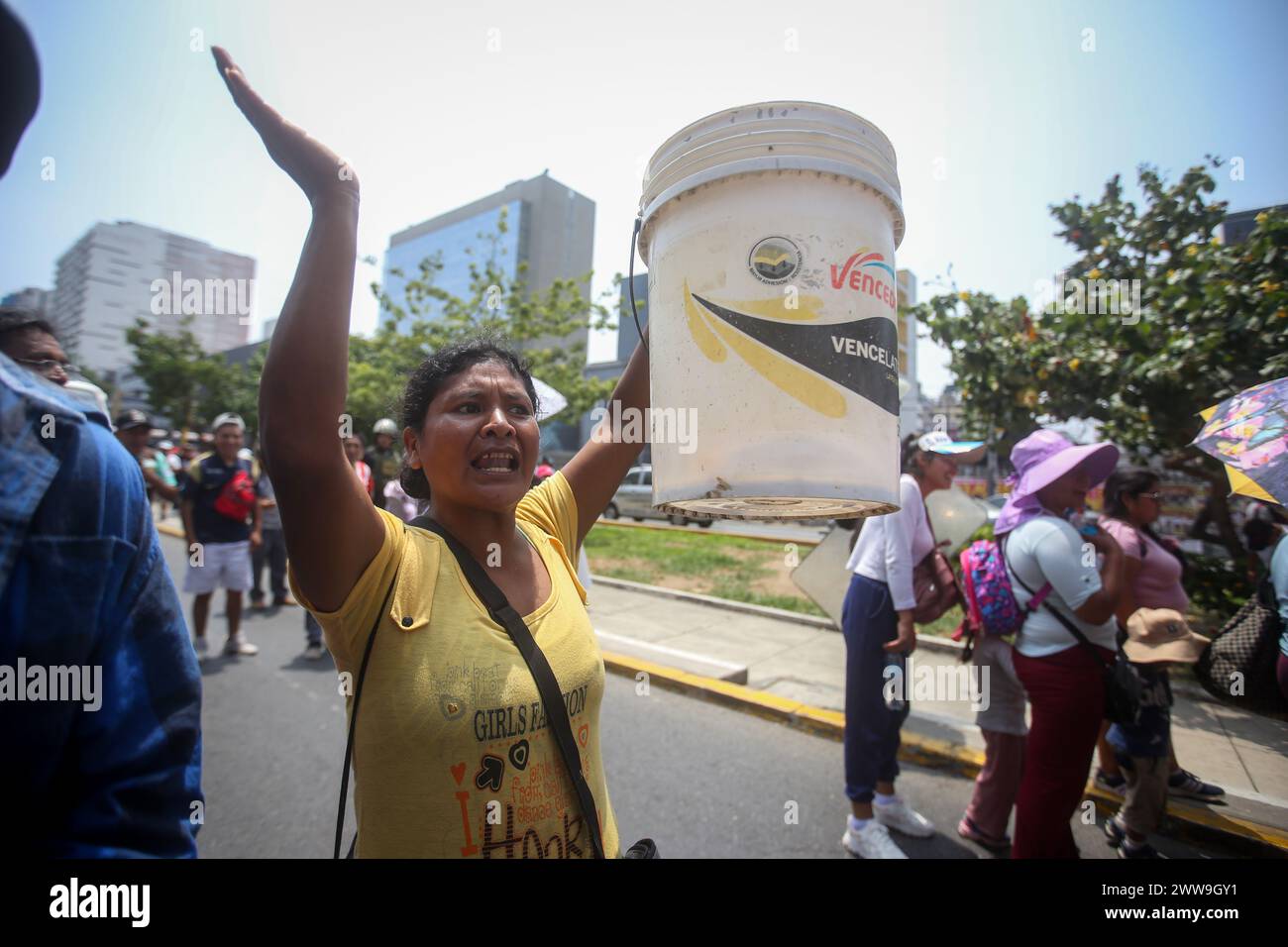 Lima, Pérou. 22 mars 2024. Une femme tient un seau dans lequel elle recueille de l’eau dans son quartier alors qu’elle participe à une manifestation contre la privatisation de l’approvisionnement en eau potable dans la capitale à l’occasion de la Journée mondiale de l’eau. Crédit : Gian Masko/dpa/Alamy Live News Banque D'Images