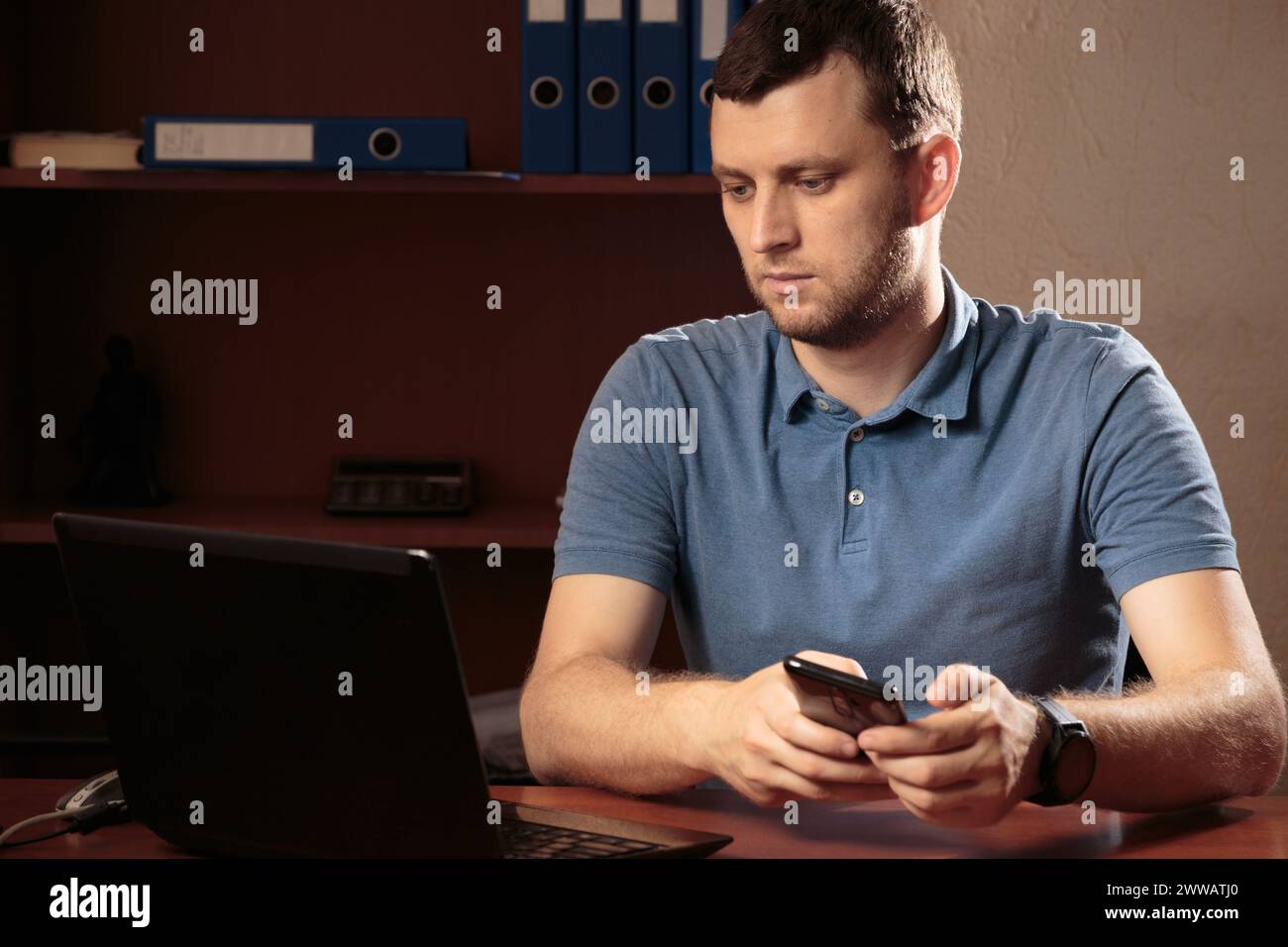 Portrait d'un jeune homme concentré. La photo a été prise dans le bureau et il y a des dossiers en arrière-plan. Gros plan. Banque D'Images