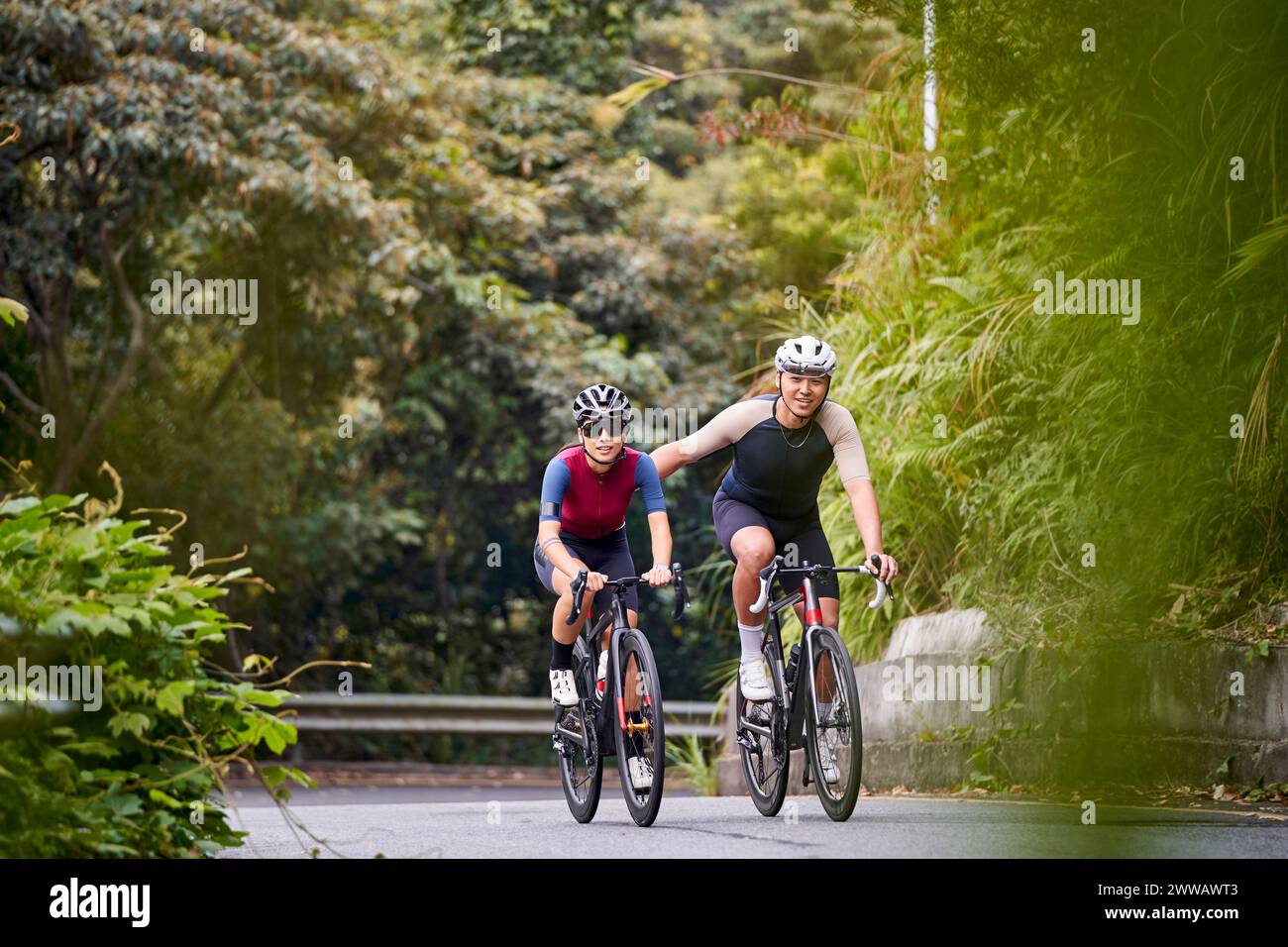 jeunes cyclistes de couple asiatique faisant du vélo sur la route rurale Banque D'Images