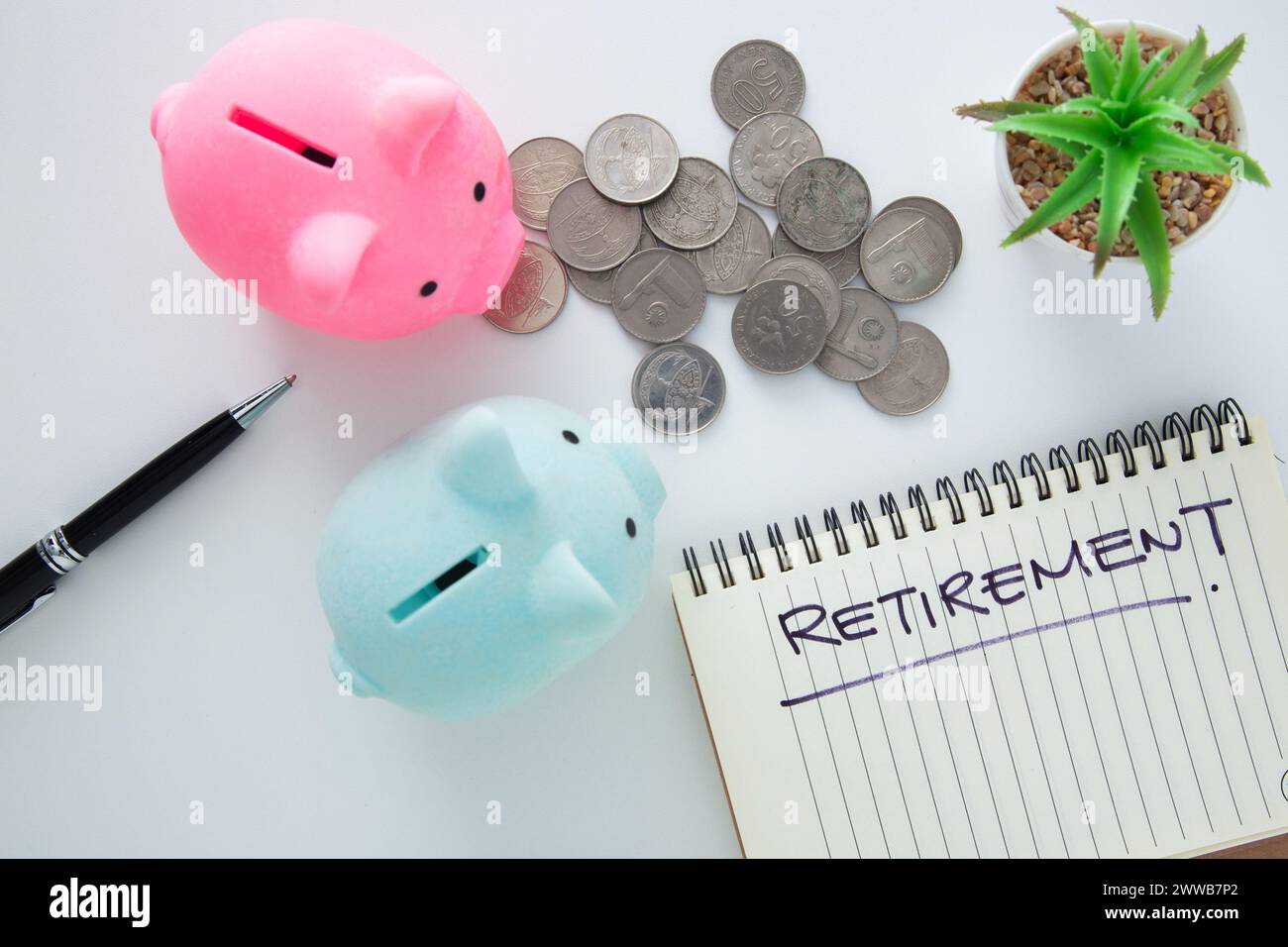 Tirelires, pièces de monnaie et un bloc-notes avec "retraite" écrit, représentant la planification financière Banque D'Images