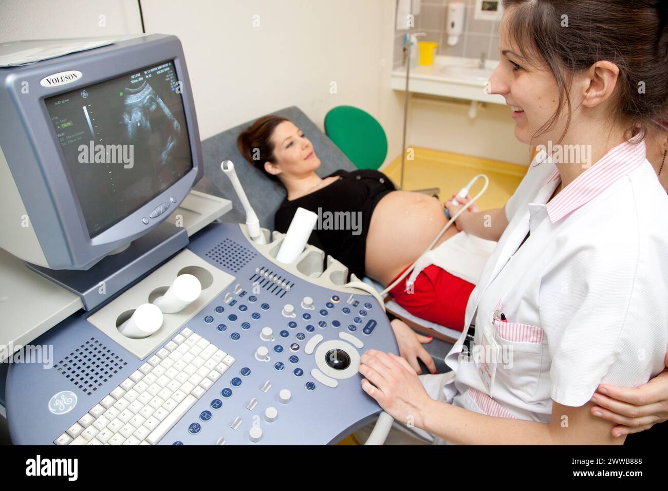 Hôpital. Maternité. étudiante sage-femme de 4e année réalisant une échographie prénatale sous la supervision d'une sage-femme. 24 semaines, 6 mois femme enceinte. Banque D'Images